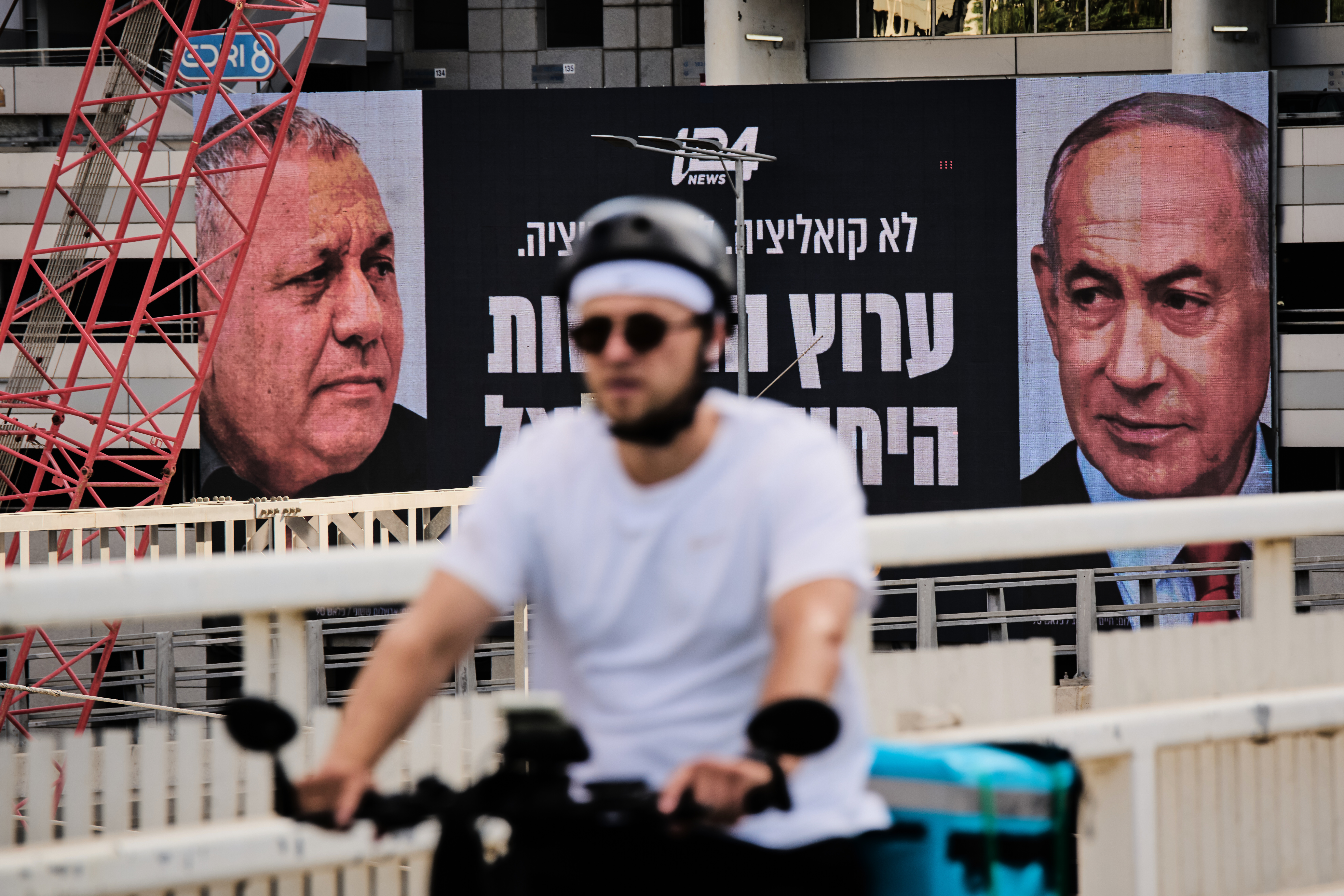 A man rides bicycle past a television channel advertisement featuring Israeli Prime Minister Benjamin Netanyahu, right, and his main rival, opposition candidate Gadi Eisenkot, ahead of Israel's general election, in Ramat Gan, Israel, Wednesday, Sept. 23, 2026. (AP Photo/Oded Balilty)