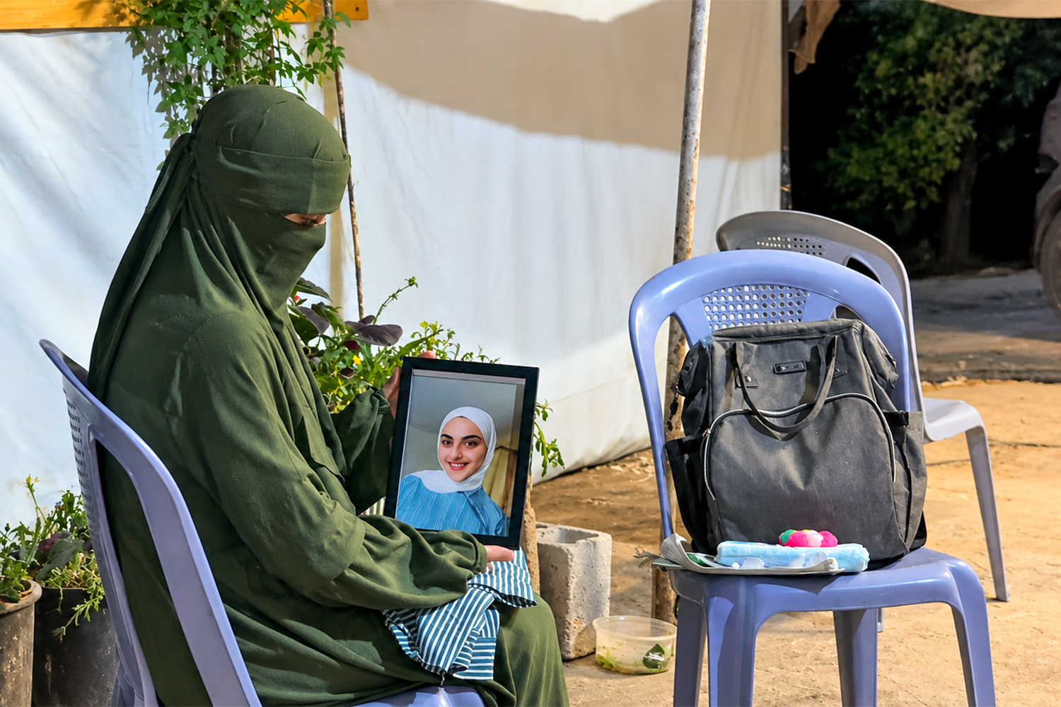 Asia is looking at her sister’s photo missing her deeply. [Moath Ghannam/Al Jazeera]