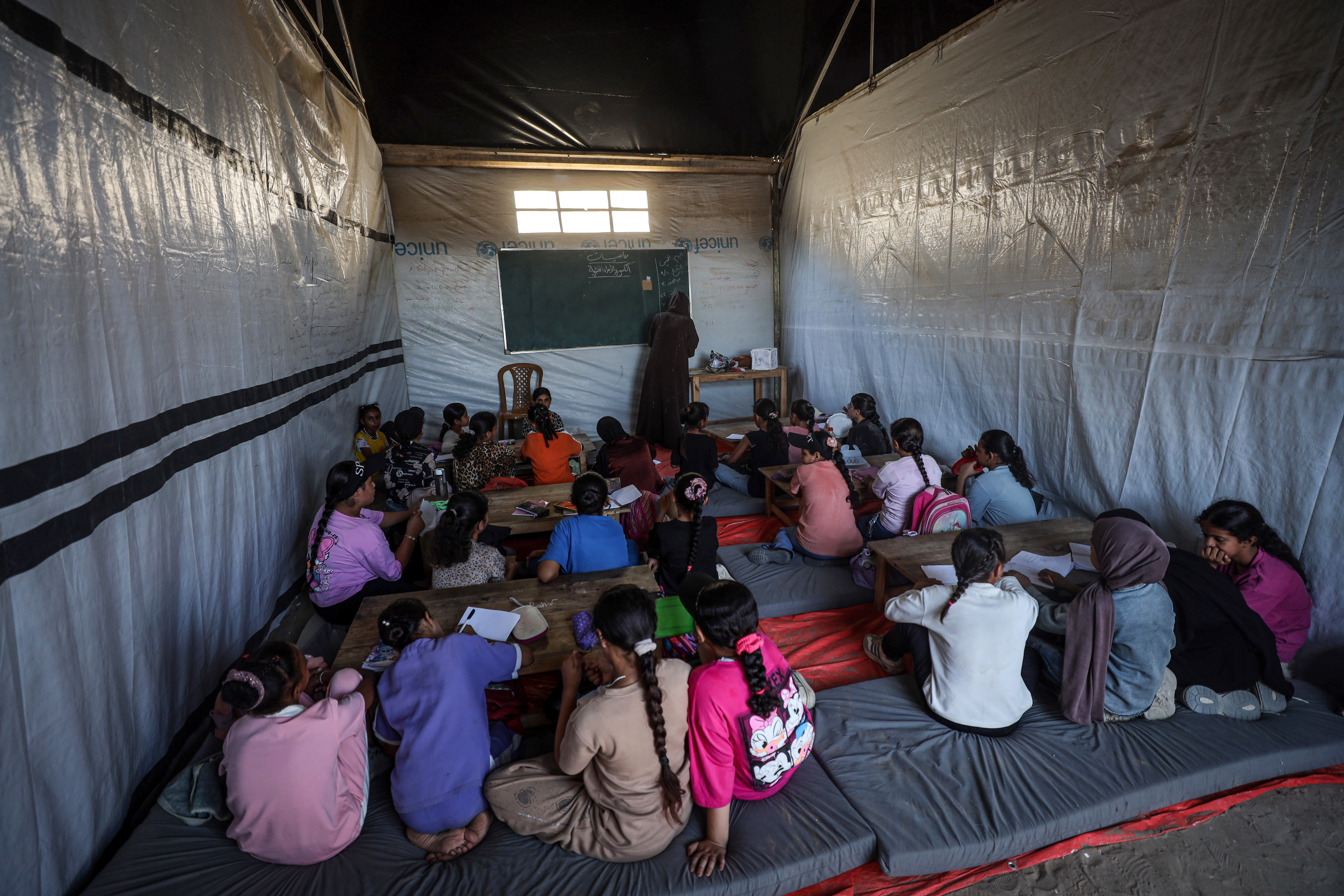 Students attend classes at the Elyaa School, which is operating from tents in Deir al-Balah, central Gaza, with limited resources. [Abdelhakim Abu Riash/ Al Jazeera]