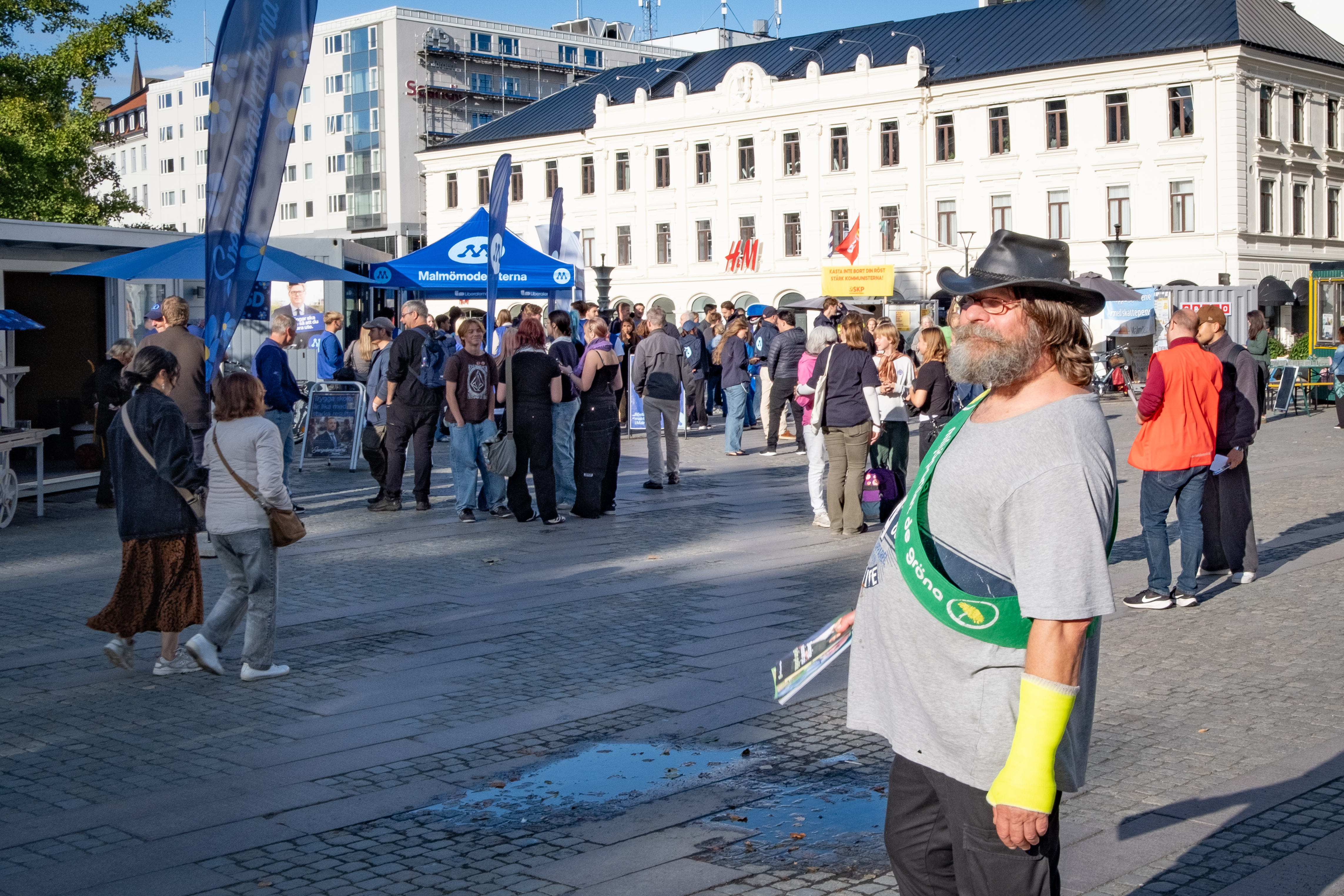 A Green Party campaigner in Malmo, behind are stands belonging to the Moderate Party and Communist Party of Sweden, September 9, 2026