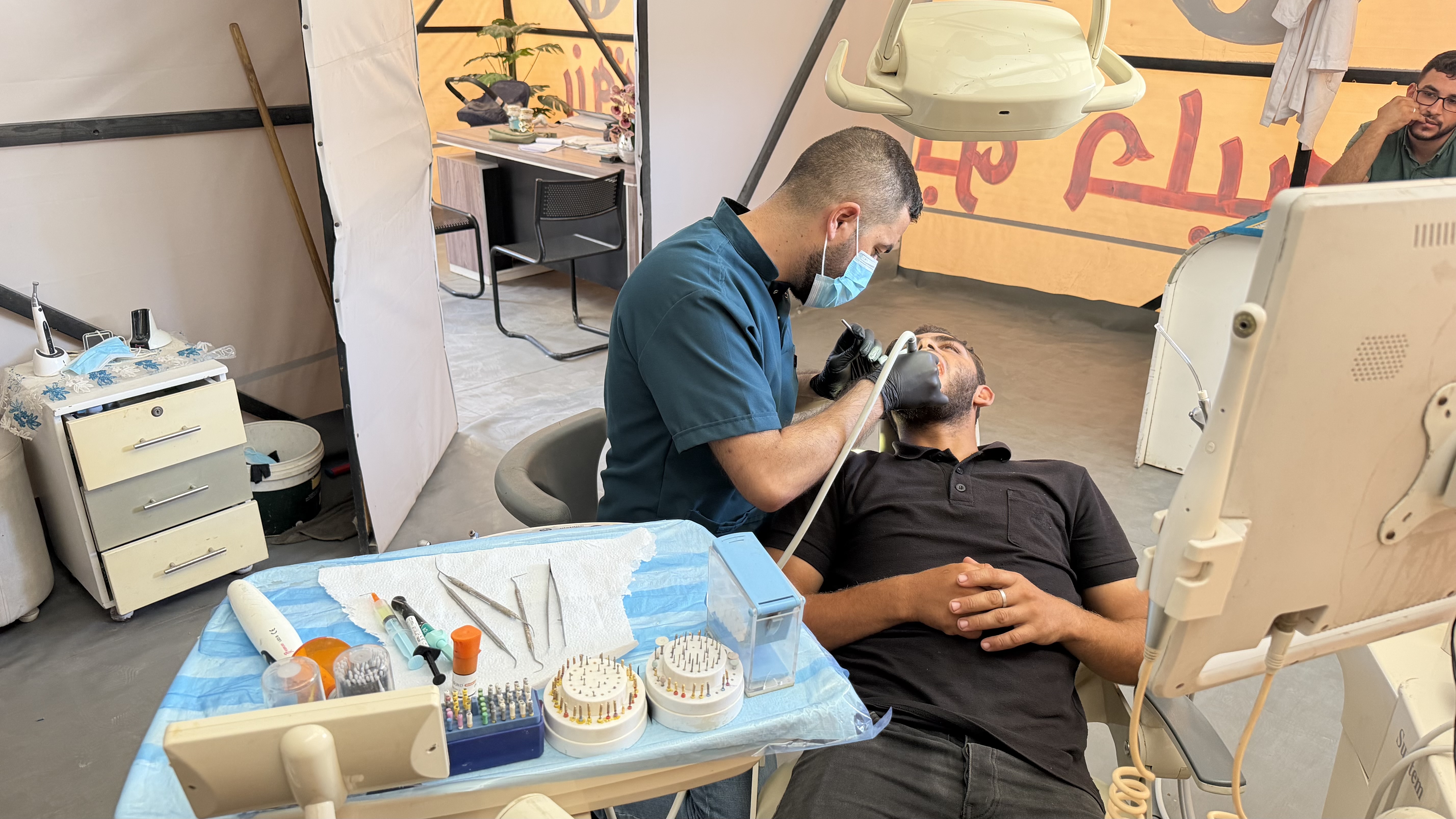 Dentist treating a patient in a tent
