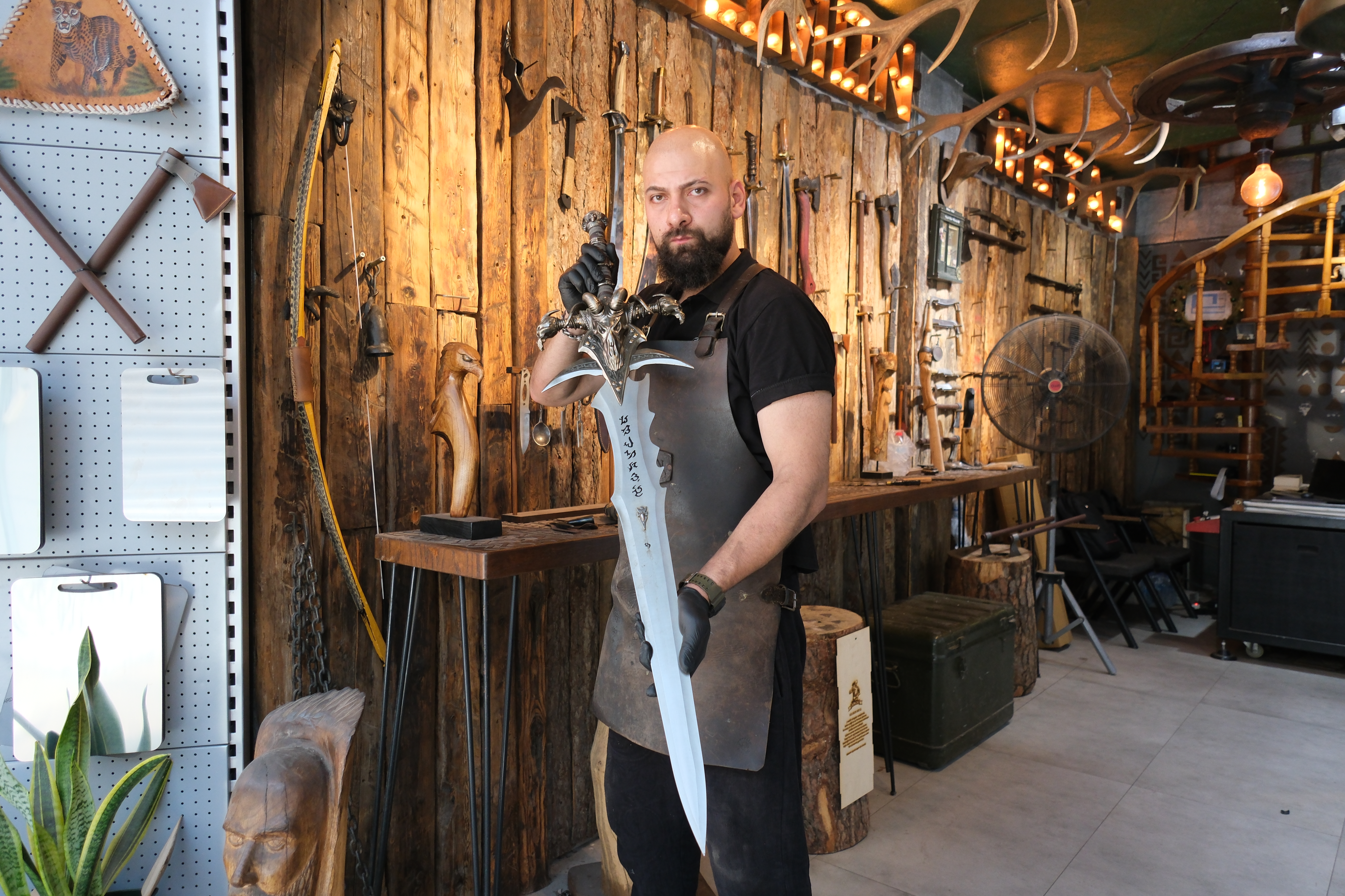 Suleyman Akdemir holds a steel recreation of Frostmourne, the famed sword from World of Warcraft, at the Kemeraltı forge where his family has practised blacksmithing for generations