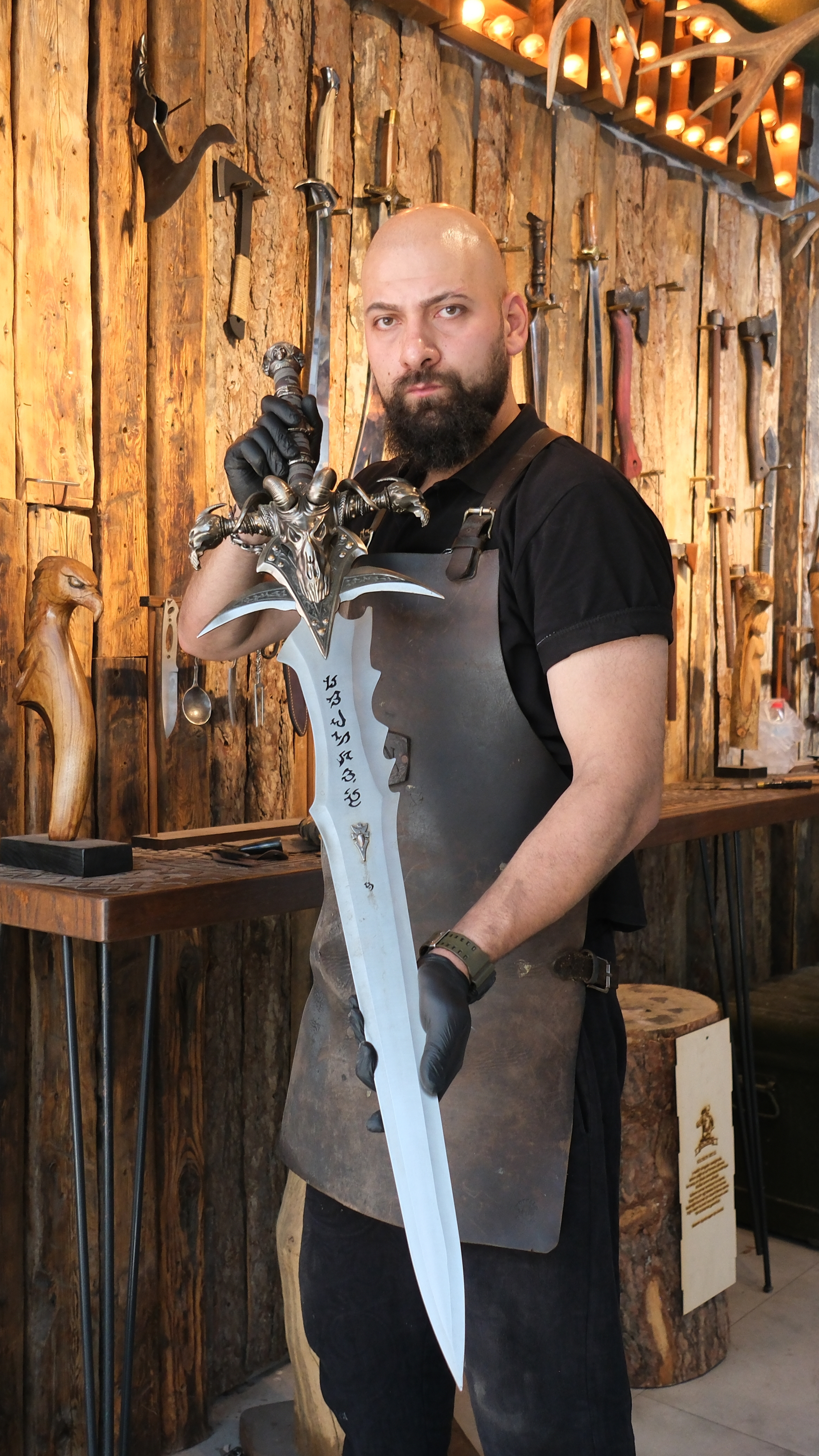 Suleyman Akdemir holds a steel recreation of Frostmourne, the famed sword from World of Warcraft, at the Kemeraltı forge where his family has practised blacksmithing for generations