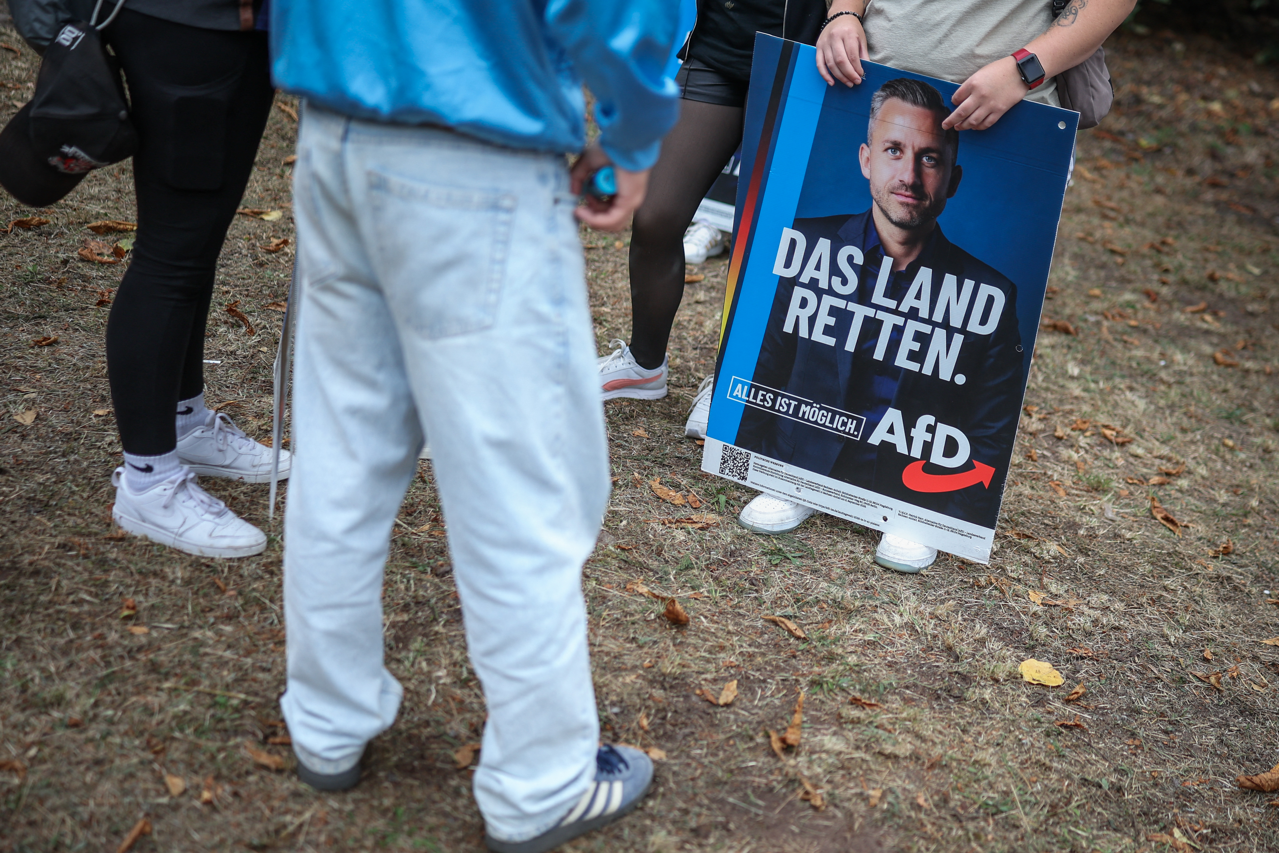 A participant holds a poster featuring a portrait of Ulrich Siegmund, the far-right Alternative for Germany (AfD)’s main candidate in the Saxony-Anhalt state election, during an election campaign event in Haldensleben, eastern Germany, on September 1, 2026