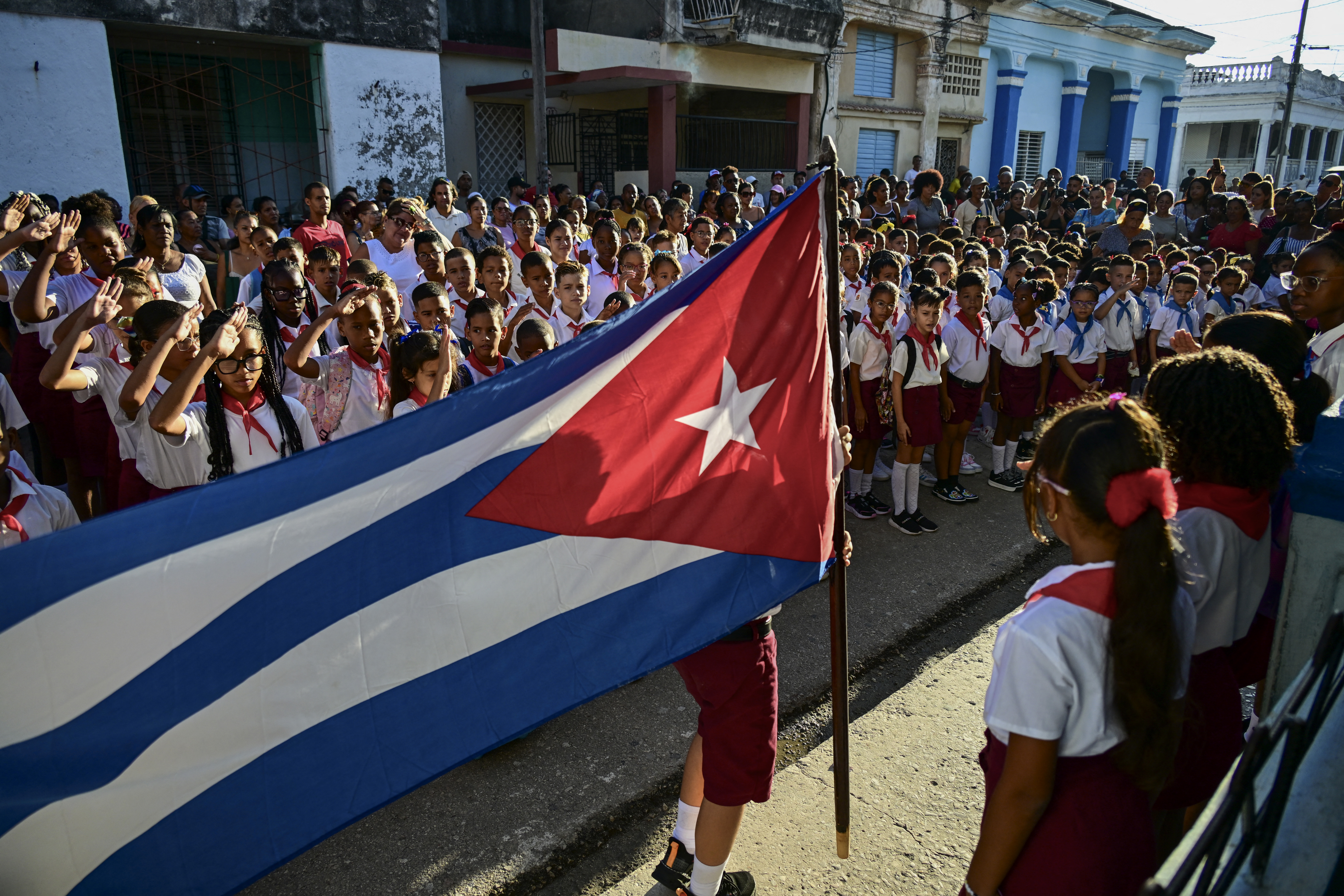 Students salute before getting into their classrooms on their first day of the 2026-2027 academic year in Havana on September 1, 2026.