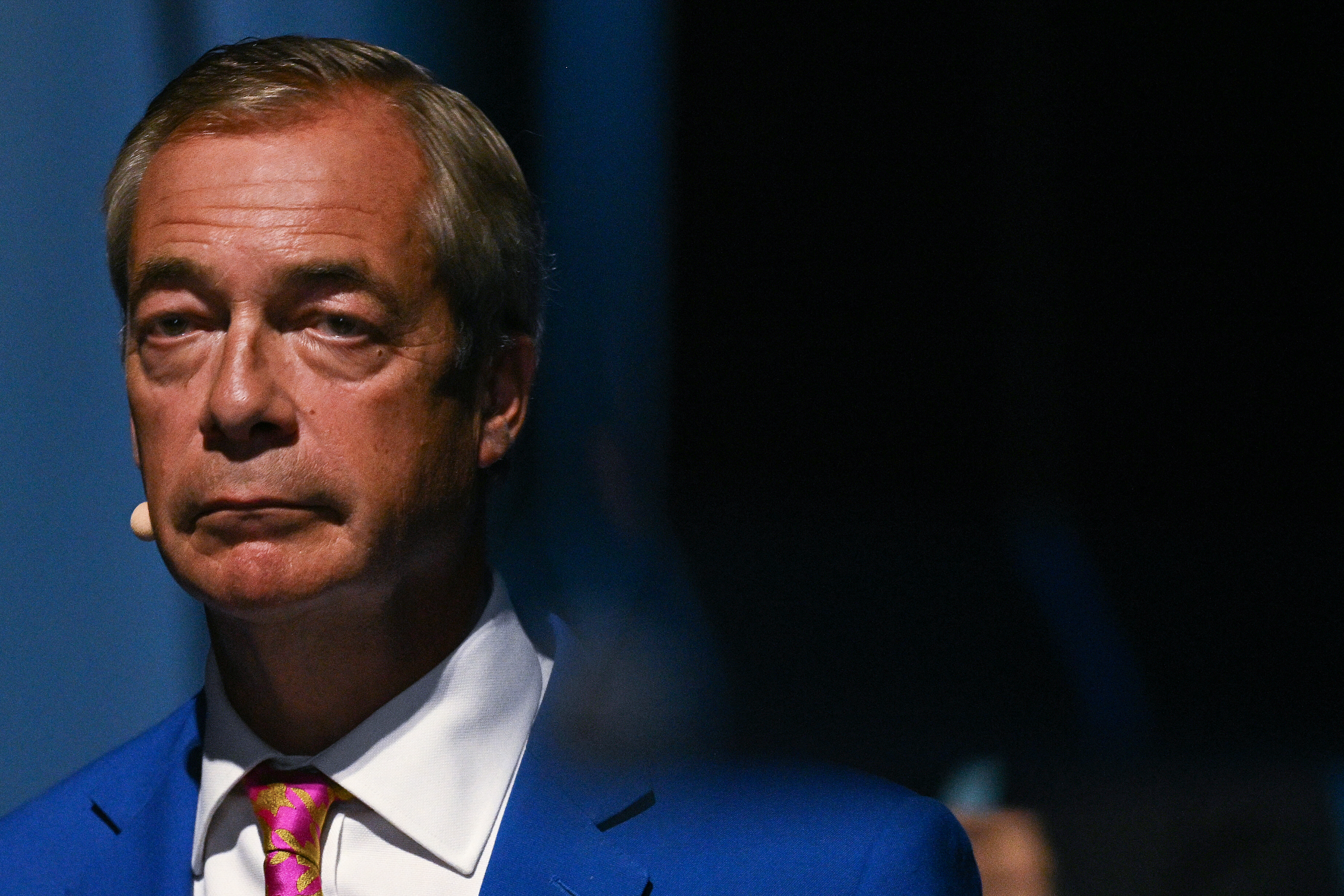 Reform UK Leader Nigel Farage stands on the sides of the stage on the second day of the annual Reform UK party conference at the NEC in Birmingham, central England on September 4, 2026. (Photo by Oli SCARFF / AFP)