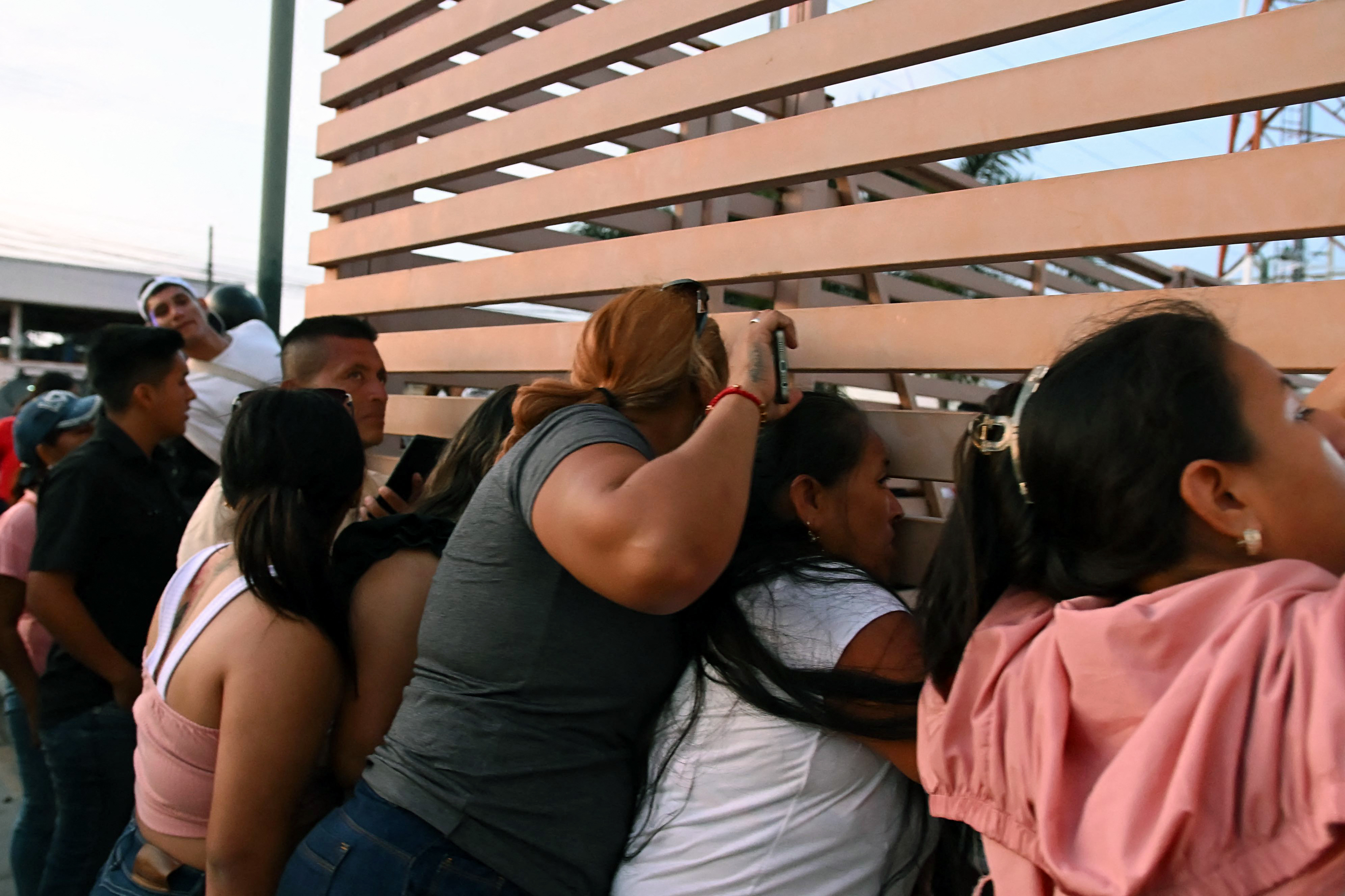 Relatives of a group of fishermen detained at the port of Manta wait outside the Community Surveillance Unit (UVC) in Manta, Ecuador. [AFP]
