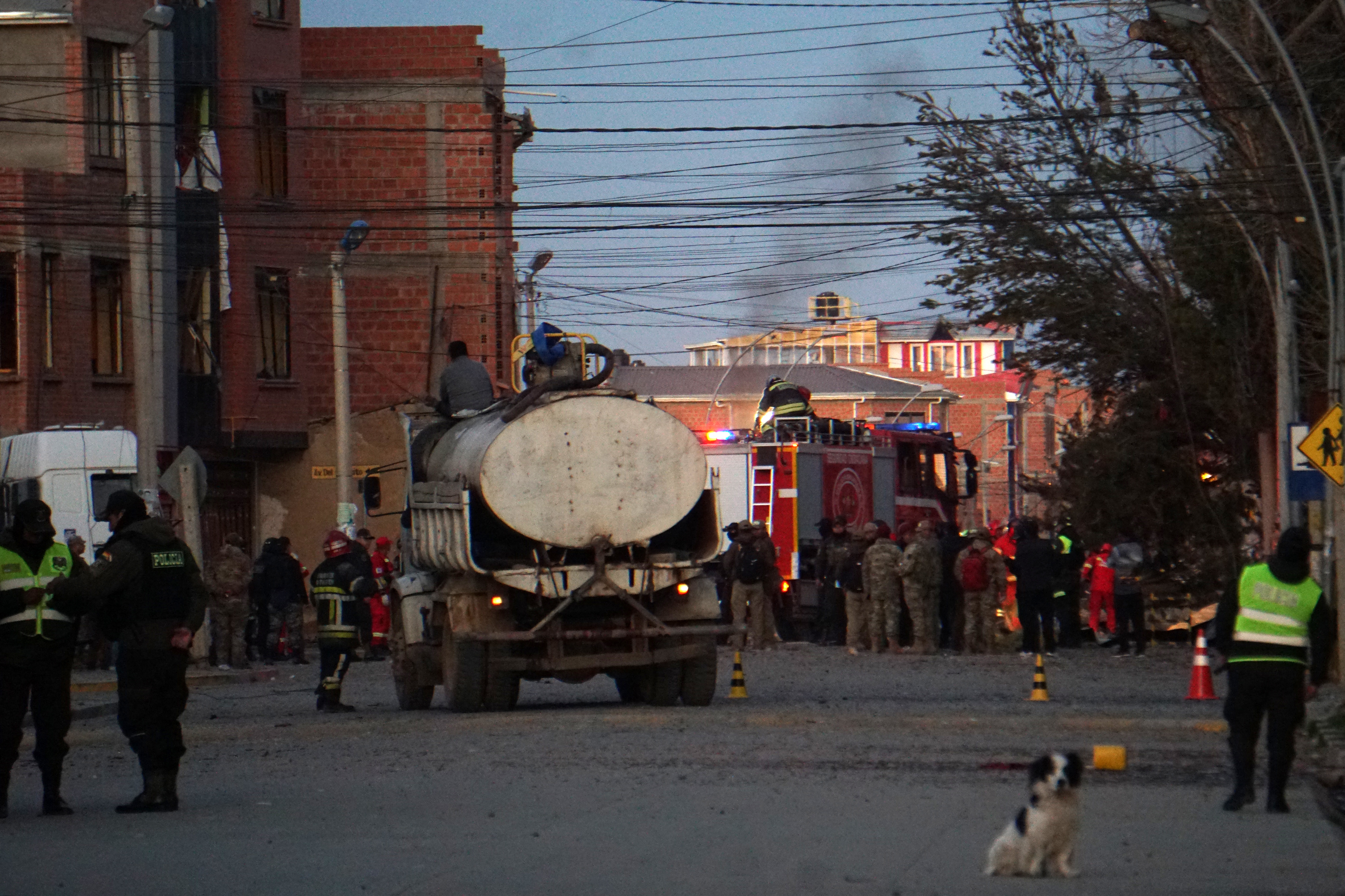 Firefighters, police officers and military personnel at the site of an explosion at an army barracks in Viacha. [AFP]