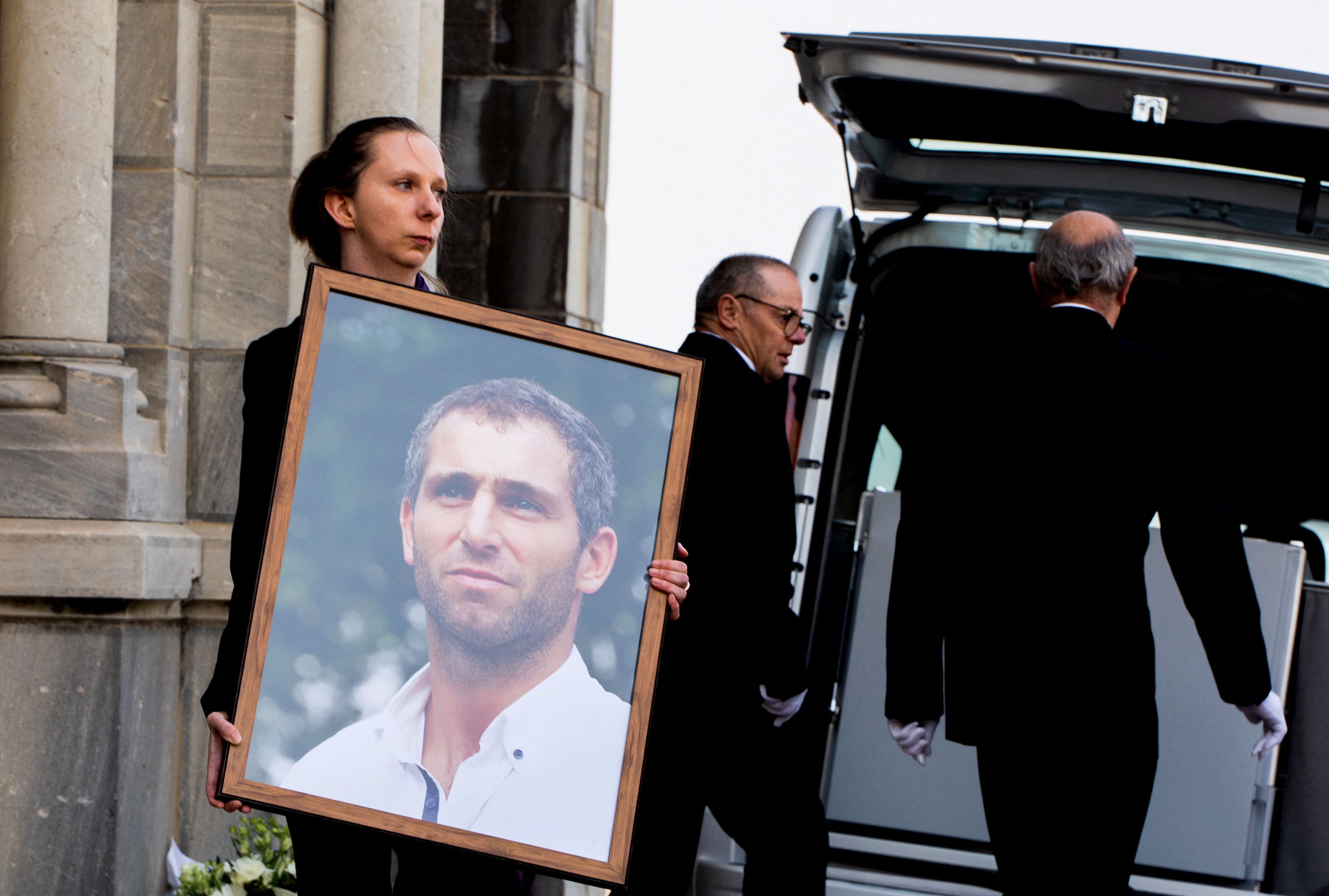 (FILES) A woman holds a portrait of Argentinian rugbyplayer Federico Martin Aramburu during his funeral in Biarritz, southwestern France, on March 26, 2022.