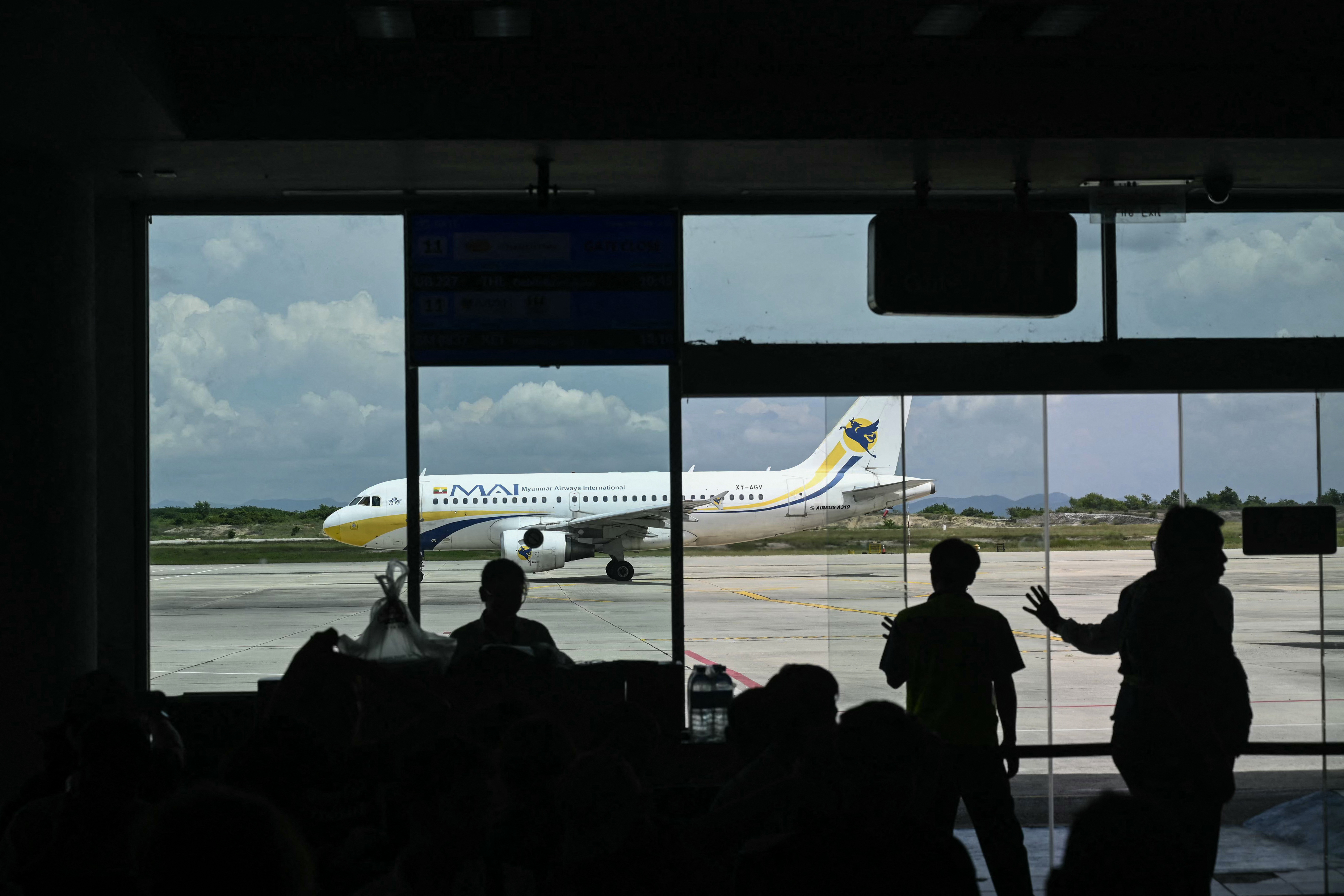 A plane is visible through an airport window.