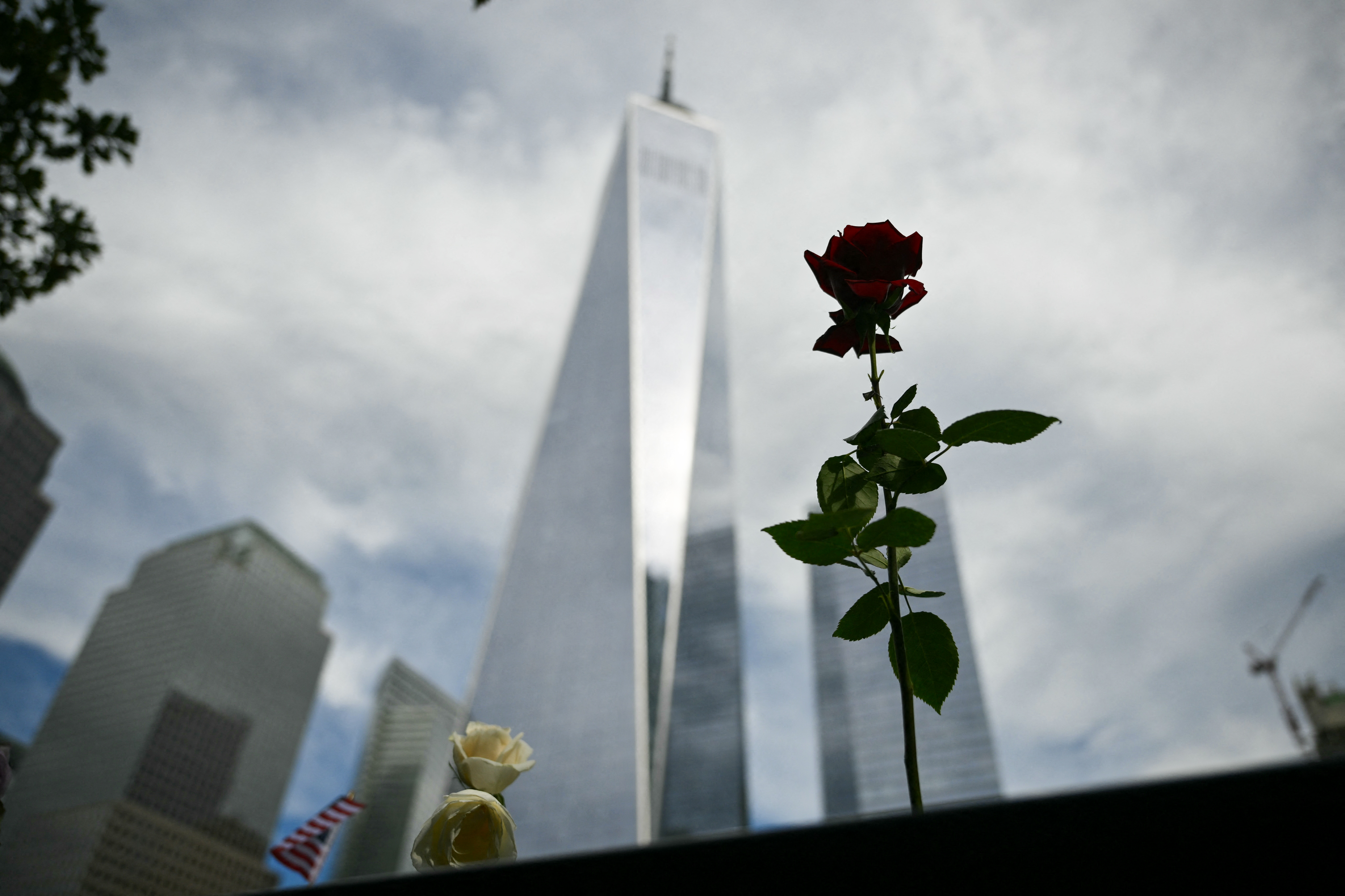One World Trade Center is seen in the background as flowers are left at the memorial during the 25th anniversary commemoration of the September 11, 2001 attacks at the National September 11 Memorial in New York on September 11, 2026. (Photo by ANGELA WEISS / AFP)