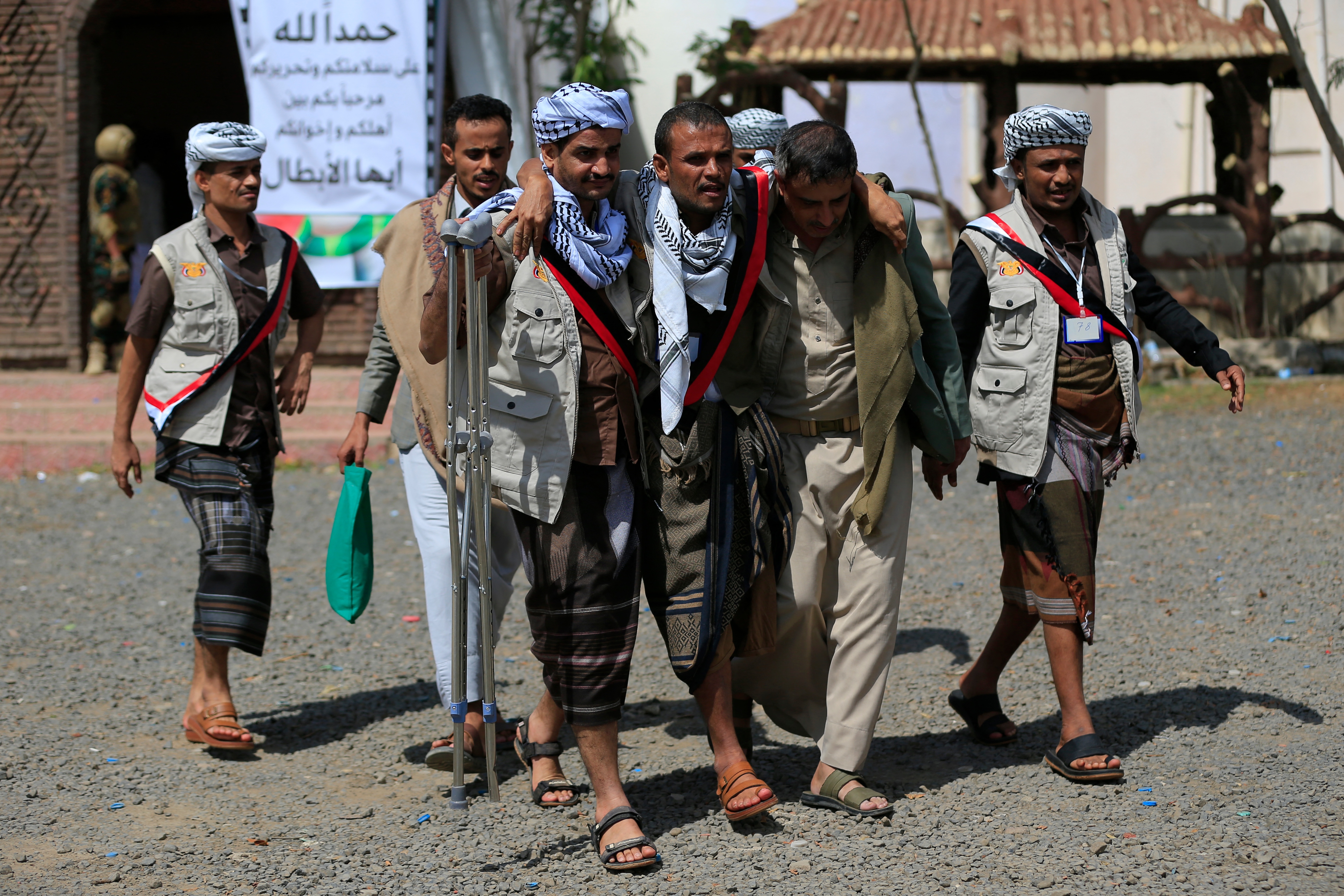Yemeni prisoners loyal to the Houthi authorities help an injured comrade after being released on the west coast where they were being held by Yemen's Saudi-backed government forces, as they arrive in the capital Sanaa on September 12, 2026.