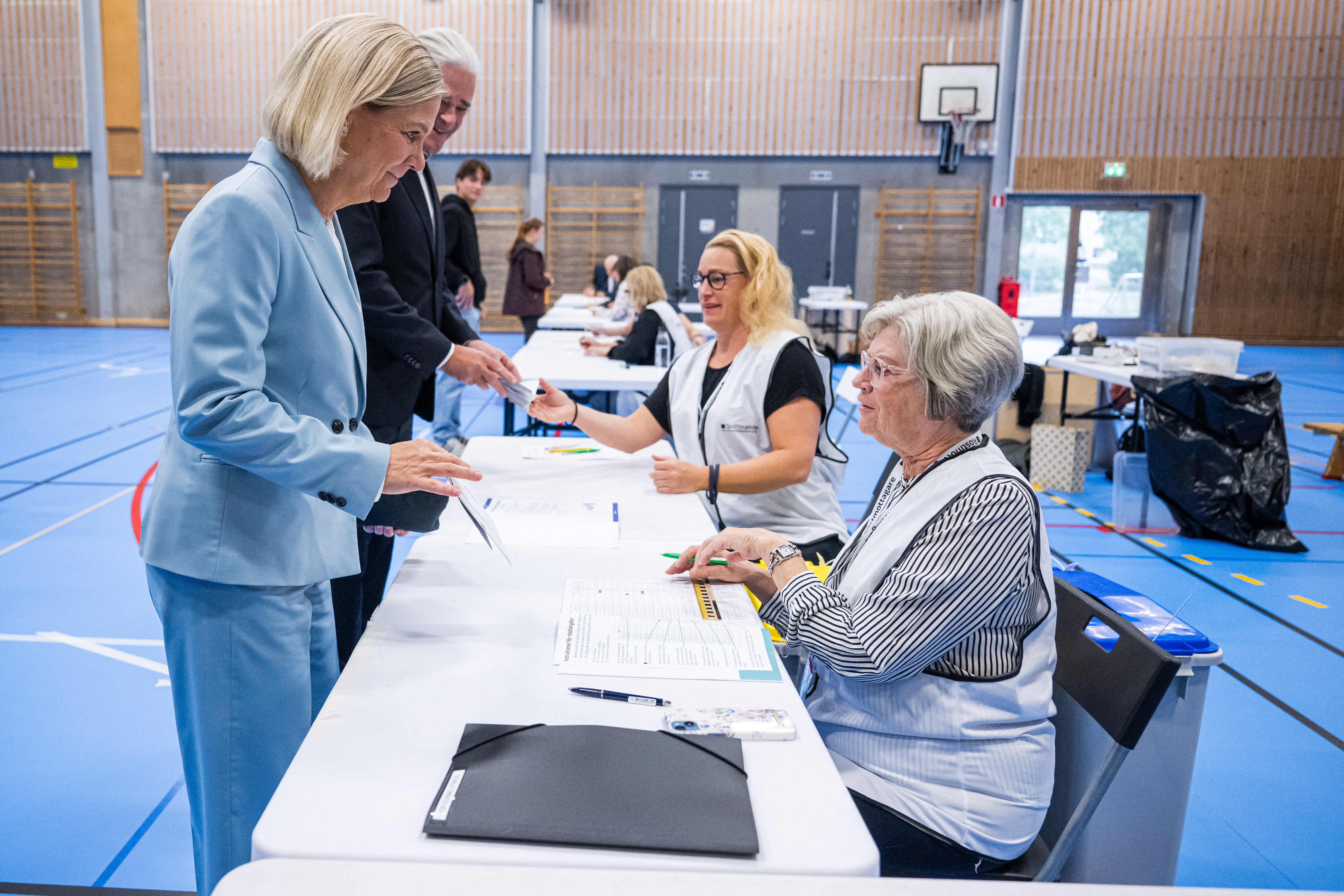 Social Democratic Party leader Magdalena Andersson (L) and her husband Richard Friberg (R) cast their votes at a polling station in a school during Sweden’s general election, in Nacka on September 13, 2026 [AFP]