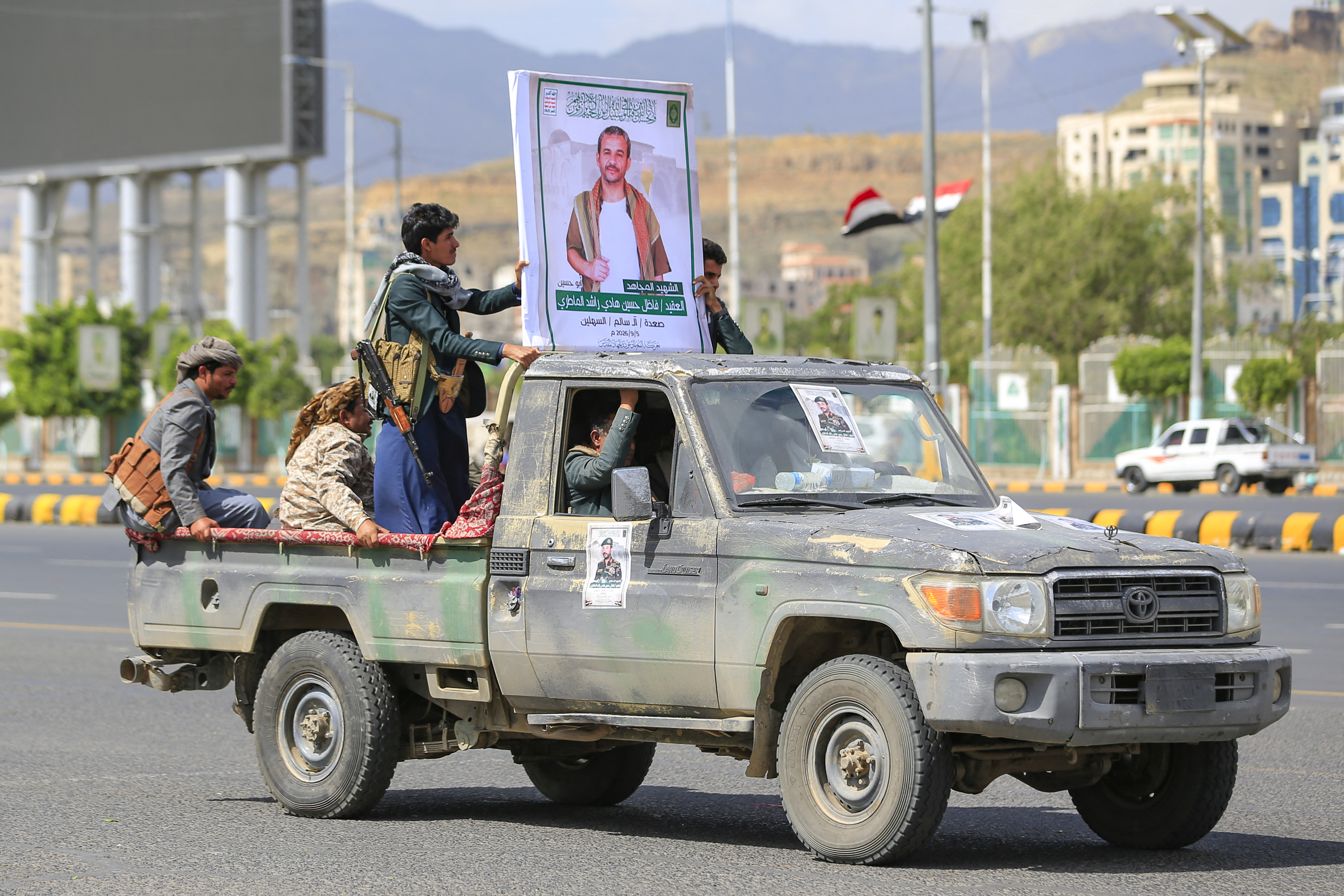 A pickup truck with a portrait of a fighter loyal to the Houthi authorities drives past during his funeral after he was killed in recent fighting, in Yemen's capital Sanaa on September 17, 2026.