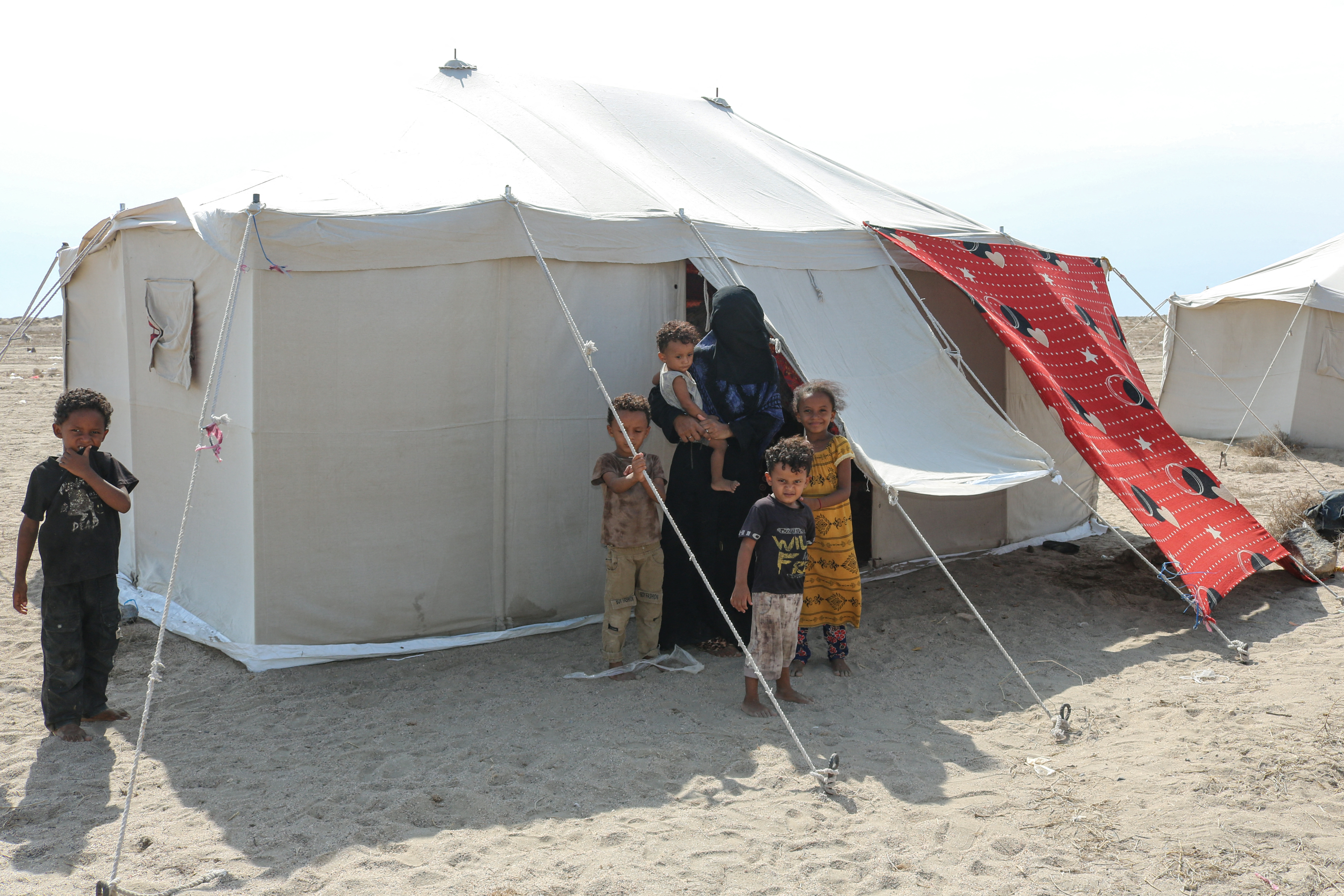 Internally displaced people (IDPs) are seen outside their tent at Al-Farsi displacement camp in Ras Imran on the outskirts of Al-Buraiqah district in southwest Aden in southern Yemen on September 17, 2026.