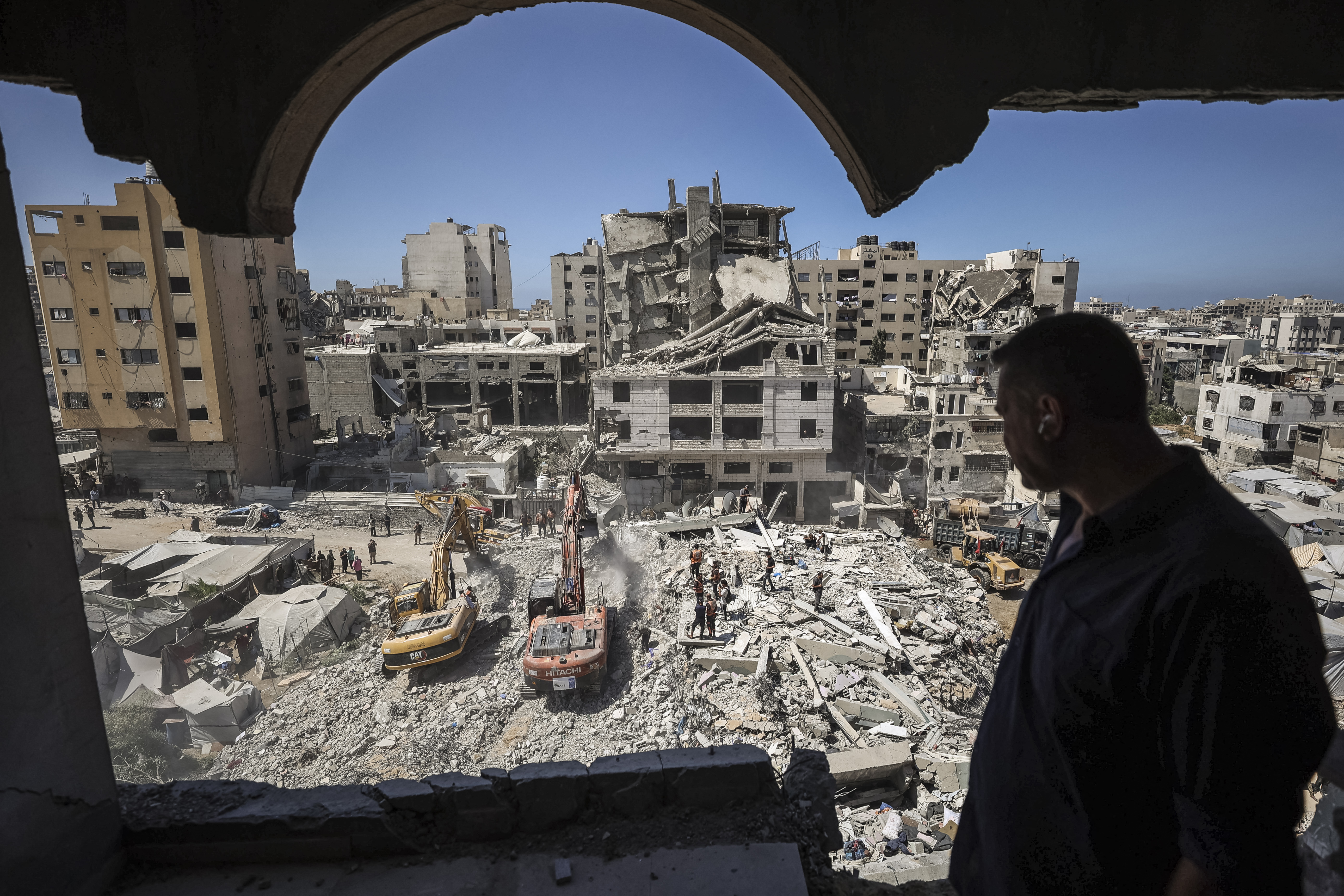 Rescuers excavate rubble to retrieve bodies from a collapsed building in the Tal al-Hawa area of Gaza City [AFP]