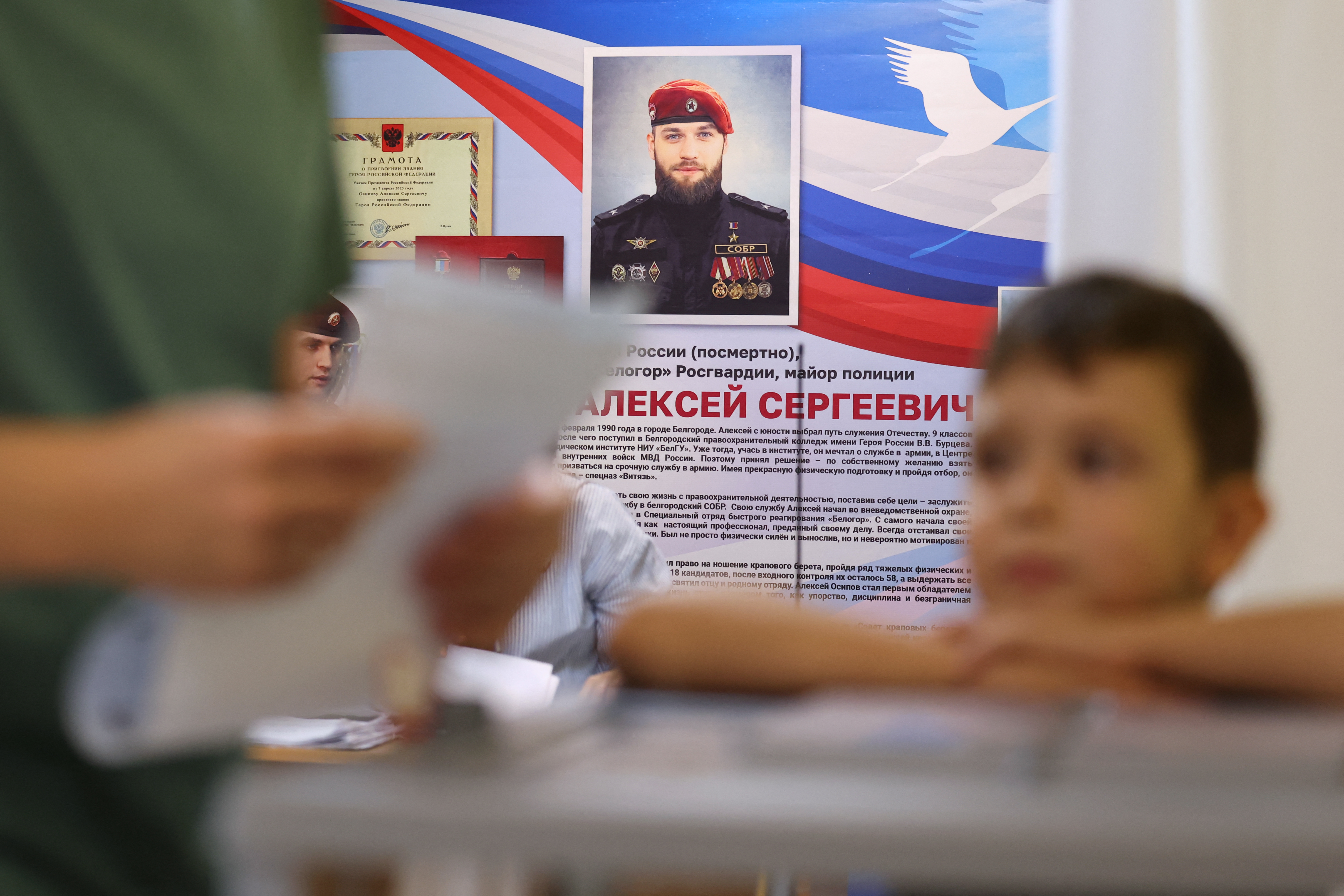 A man casts his ballot for Russia's parliamentary election at a polling station named after Alexey Osipov, the Russian National Guard (Rosgvardiya) officer killed in the course of the Russian-Ukrainian conflict and posthumously awarded with the Gold Star medal of "Hero of Russia", in the school also bearing his name in the settlement of Razumnoye in the Belgorod region on September 19, 2026. (Photo by STRINGER / AFP)