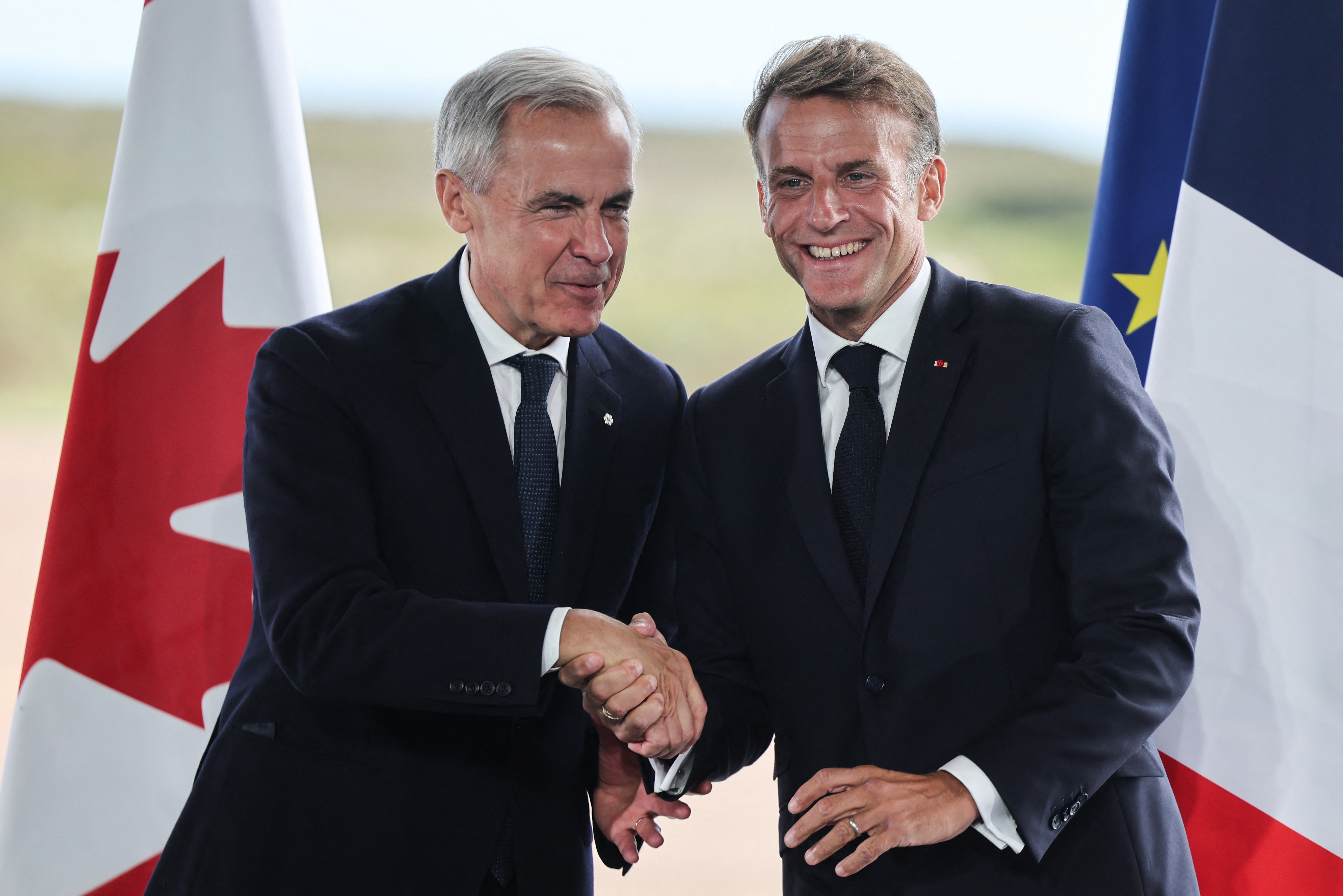 France's President Emmanuel Macron (R) and Canada's Prime Minister Mark Carney (L) hold a joint press statement in Saint-Pierre on September 20, 2026, during Macron's visit to the French self-governing overseas collectivity of Saint-Pierre-et-Miquelon.