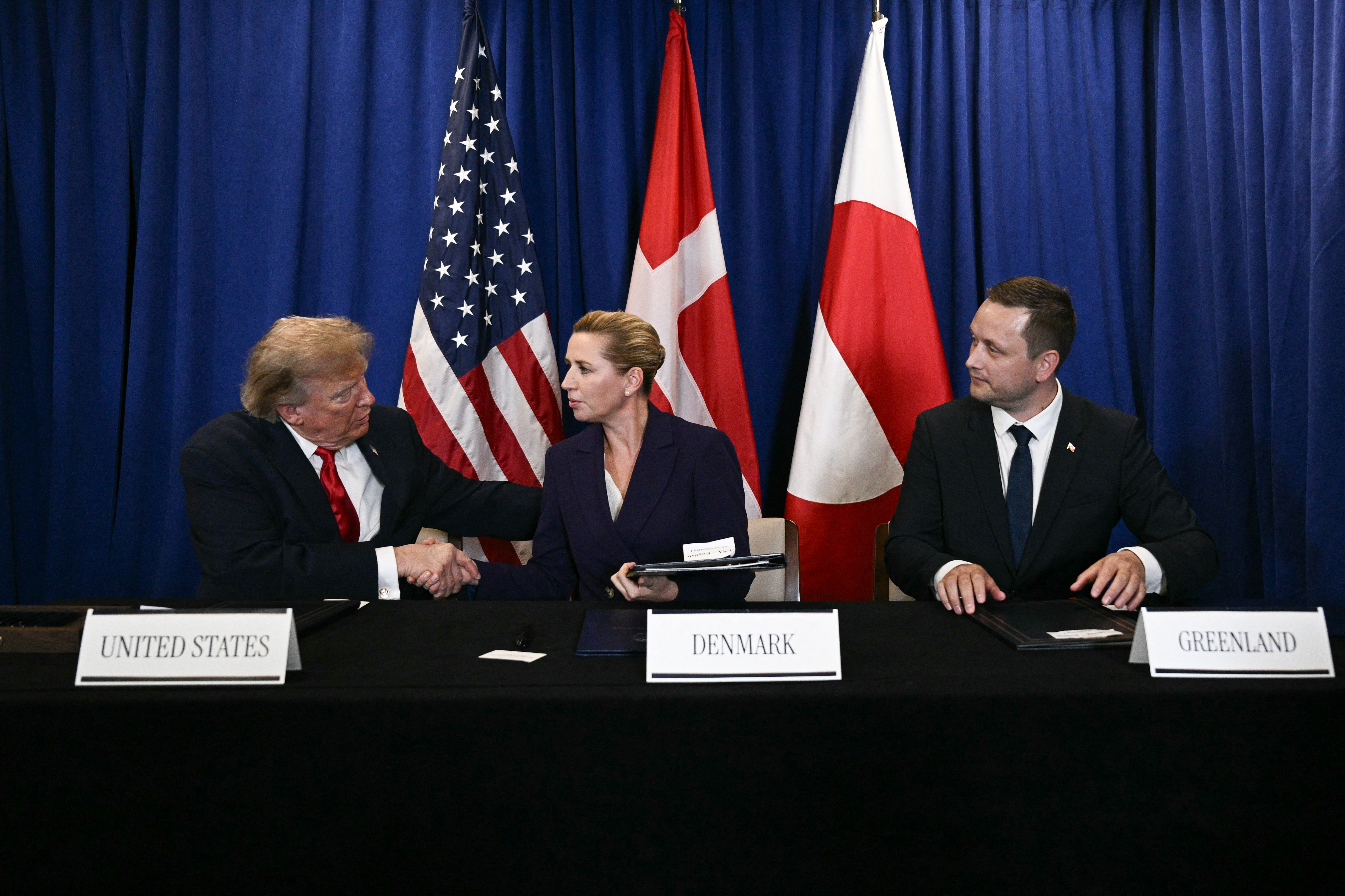 (L/R) US President Donald Trump shakes hands with Denmark's Prime Minister Mette Frederiksen as Greenland's Prime Minister Jens-Frederik Nielsen looks on after they signed a trilateral security deal on the sidelines of the 81st United Nations General Assembly in New York, on September 22, 2026. (Photo by Brendan SMIALOWSKI / AFP)