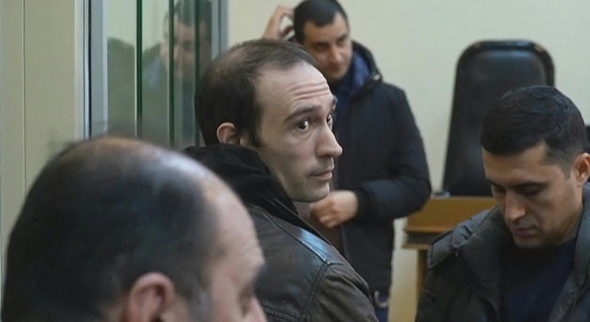 (FILES) This grab taken from footage released by AFP video on January 6, 2025, shows French national Martin Ryan (C) during a court hearing as part of his trial on spy charges in Baku.