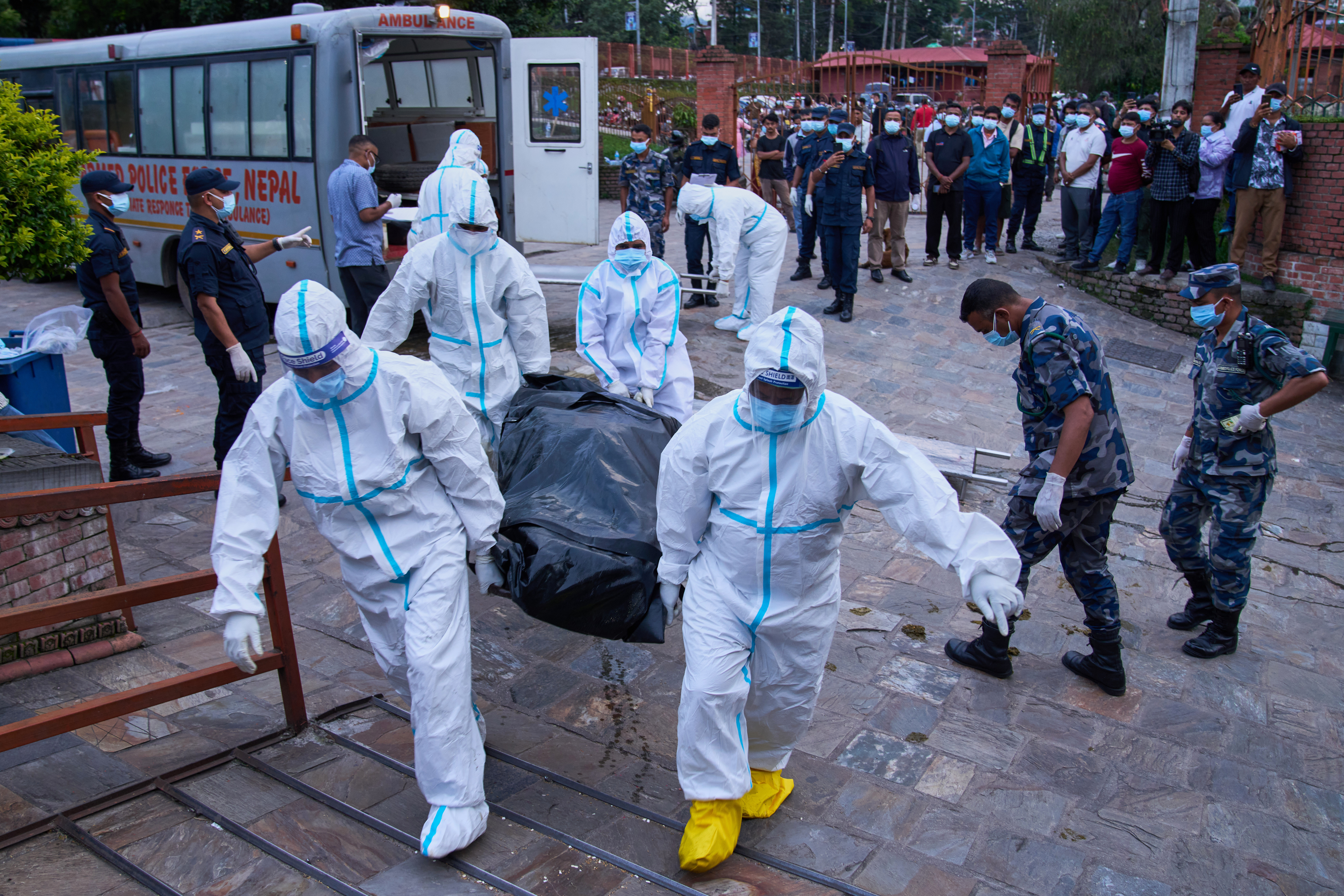 Police personnel in protective suits bring the body of an unidentified victim of flash floods for storage at a crematorium in Kathmandu, Nepal, Wednesday, Sept. 2, 2026. (AP Photo/Dar Yasin)