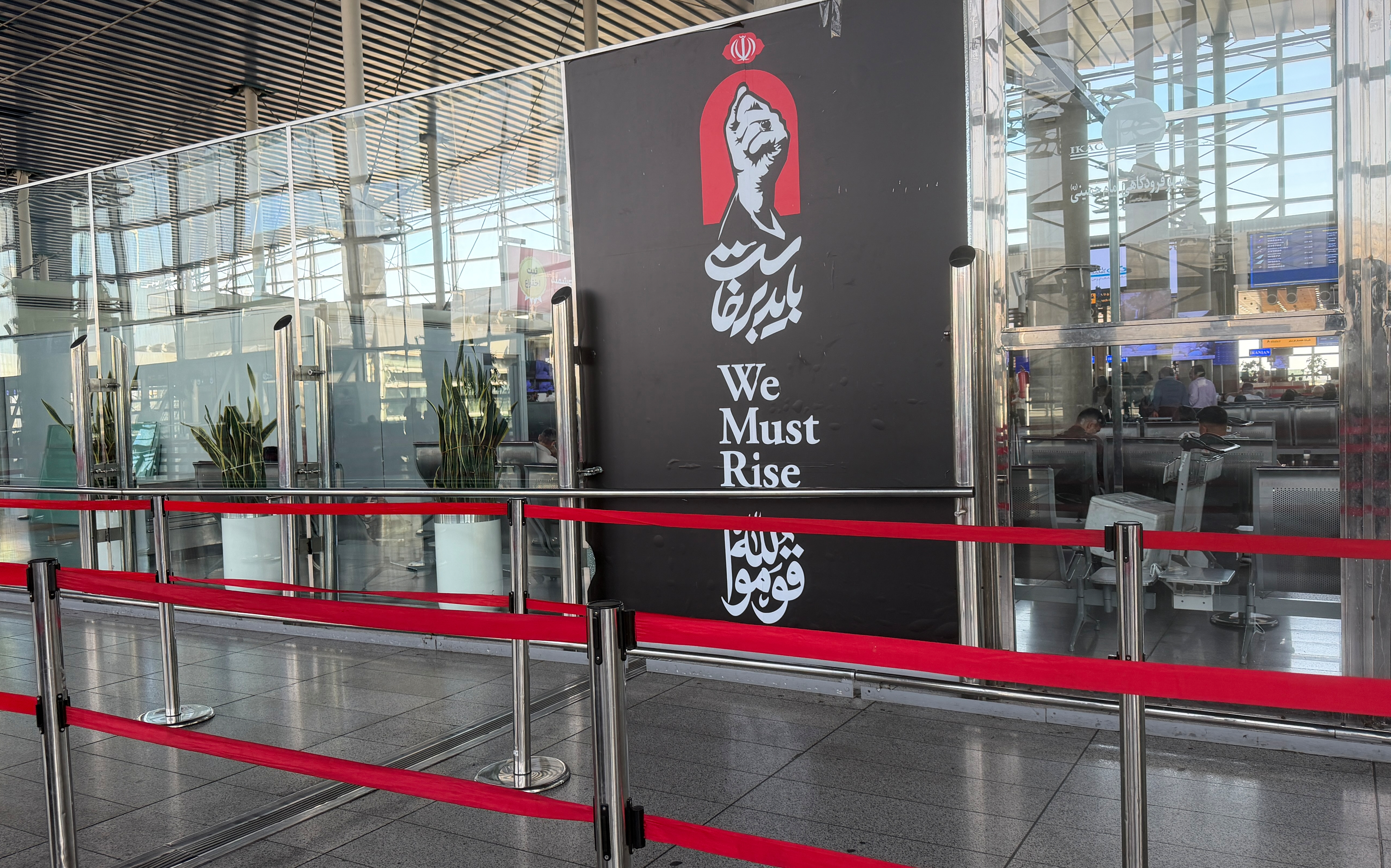 A banner depicting a clenched fist of the late Iranian Supreme Leader Ayatollah Ali Khamenei with writing that reads in Farsi:" We must rise," and a phrase from Islam's holy book the Quran: "Stand up for the sake of Allah," at Tehran's Imam Khomeini International Airport, Iran, Wednesday, Sept. 23, 2026. (AP Photo/Vahid Salemi)
