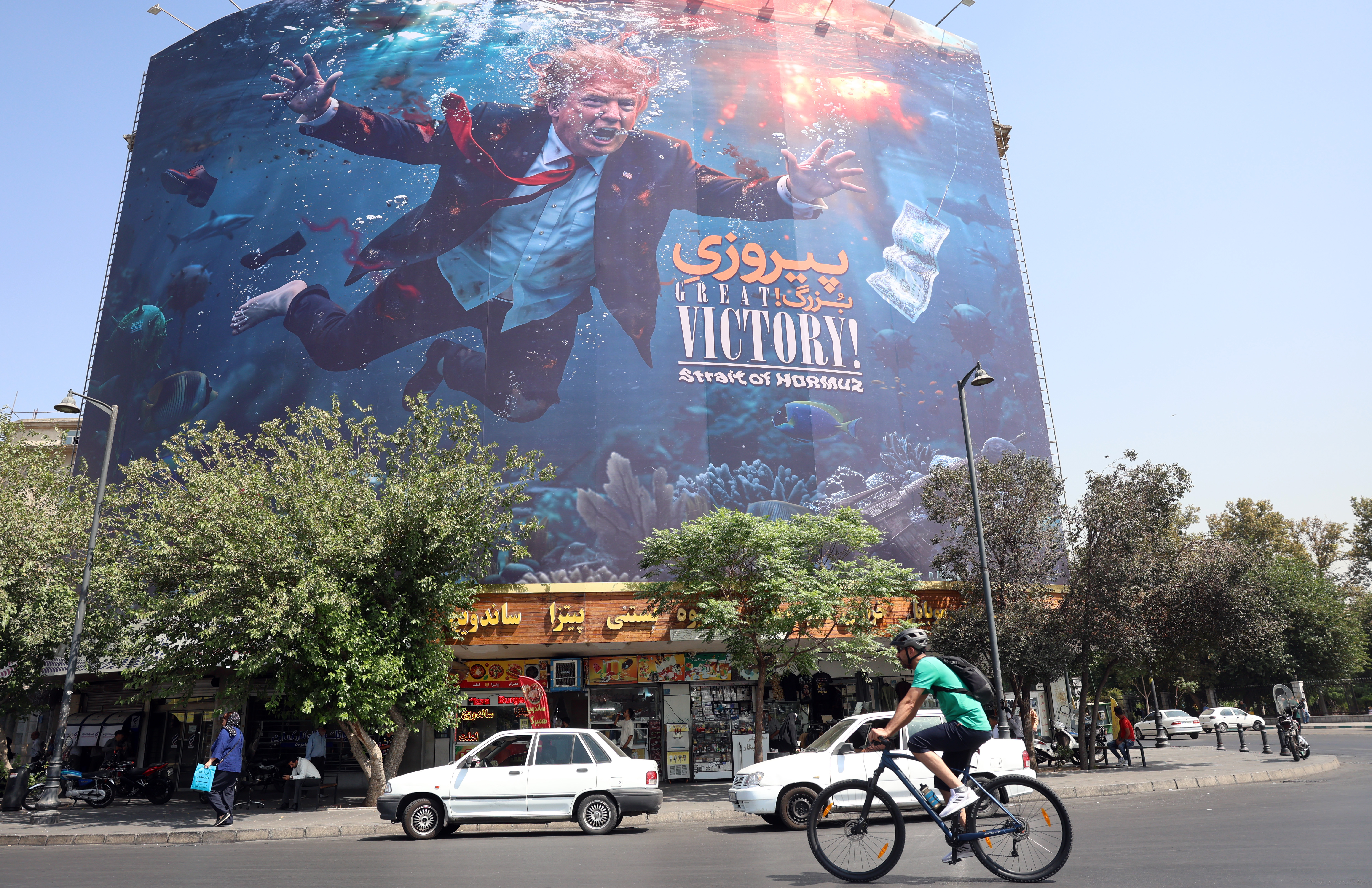 epa13188123 Iranians drive past an anti-US billboard featuring US President Donald Trump in southern Tehran, Iran, 24 August 2026. US President Donald Trump said the US will launch 'economic D-Day' sanctions against Iran as the conflict between Iran and the US continues. EPA/ABEDIN TAHERKENAREH RESTRICTIONS: NO Access Israel Media/Persian Language TV Stations Outside Iran/Strictly No Access BBC Persian/VOA Persian/Manoto TV/Iran International TV. (As mandated by Iran's Directorate General for Foreign Media) --