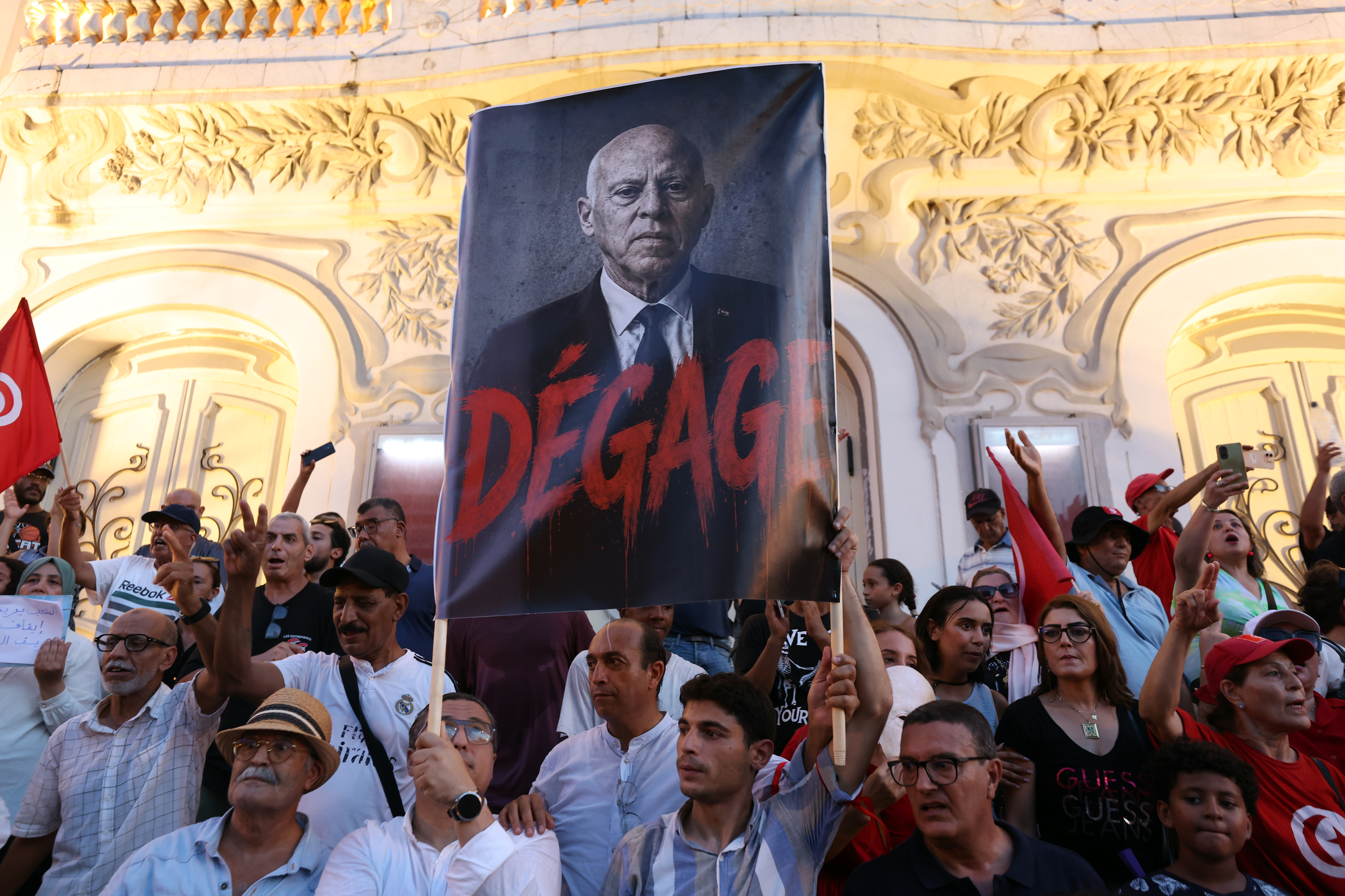 epa13181362 Tunisians hold the photo of Tunisian President Kais Saied and shout slogans during a demonstration against Saied and deteriorating living conditions, under the slogan, 'Enough of the absurdity, enough of the failure, enough of the injustice,' in Tunis, Tunisia, 20 August 2026. The demonstration, organized by the National Salvation Front and the Nafas movement, bought together opposition members and citizens denouncing the country's political, economic and social situation. EPA/MOHAMED MESSARA