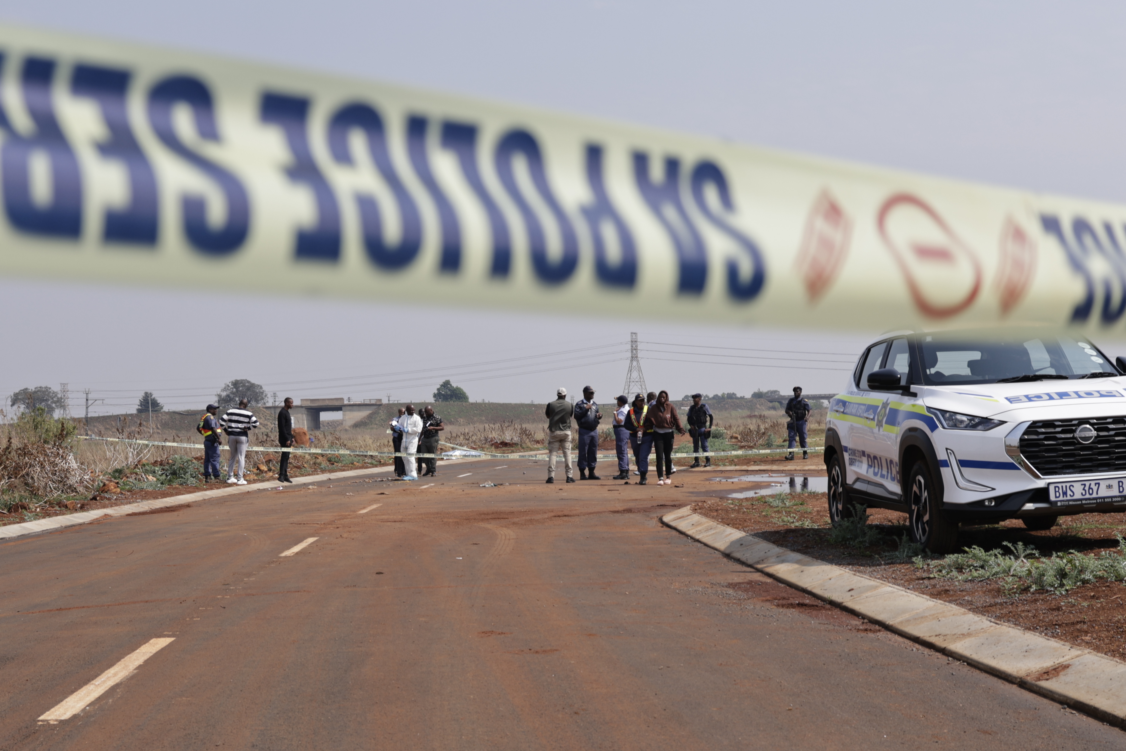 epa13245347 Members of the SAPS (South African Police Service) and state pathologists inspect the body of one of the women found dumped on the side of a road in Boksburg, Johannesburg, South Africa, 17 September 2026. The remains of nine murdered women have been found in recent weeks as SAPS tries to arrest the killer. EPA/Kim Ludbrook