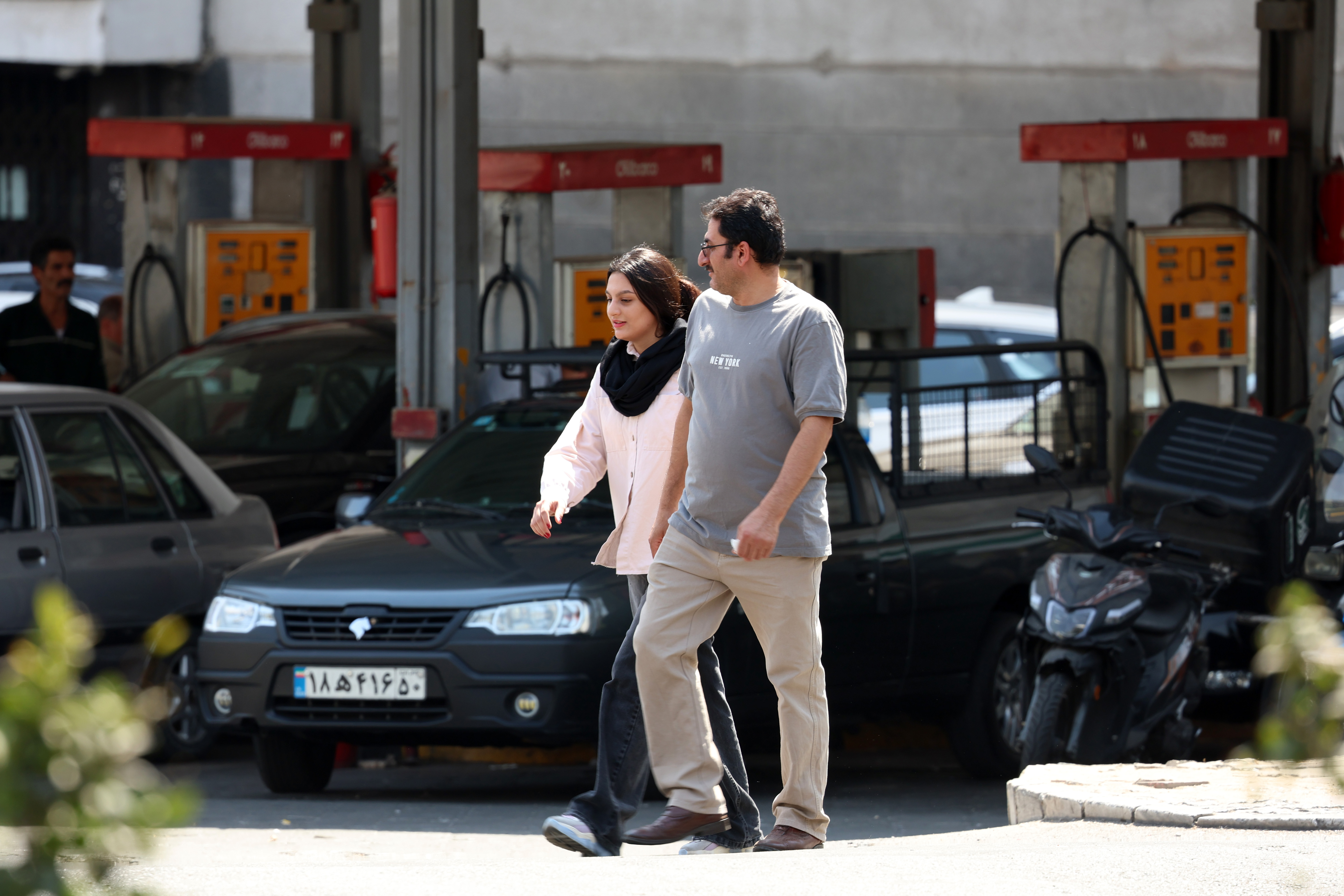 epa13219577 A couple walks past a petrol station in central Tehran, Iran, 07 September 2026. The Iranian government announced raising the price of petrol, which will be effective from 08 September 2026. EPA/ABEDIN TAHERKENAREH RESTRICTIONS:ISRAEL OUT - NO Access Israel Media/Persian Language TV Stations Outside Iran/Strictly No Access BBC Persian/VOA Persian/Manoto TV/Iran International TV. (As mandated by Iran's Directorate General for Foreign Media)