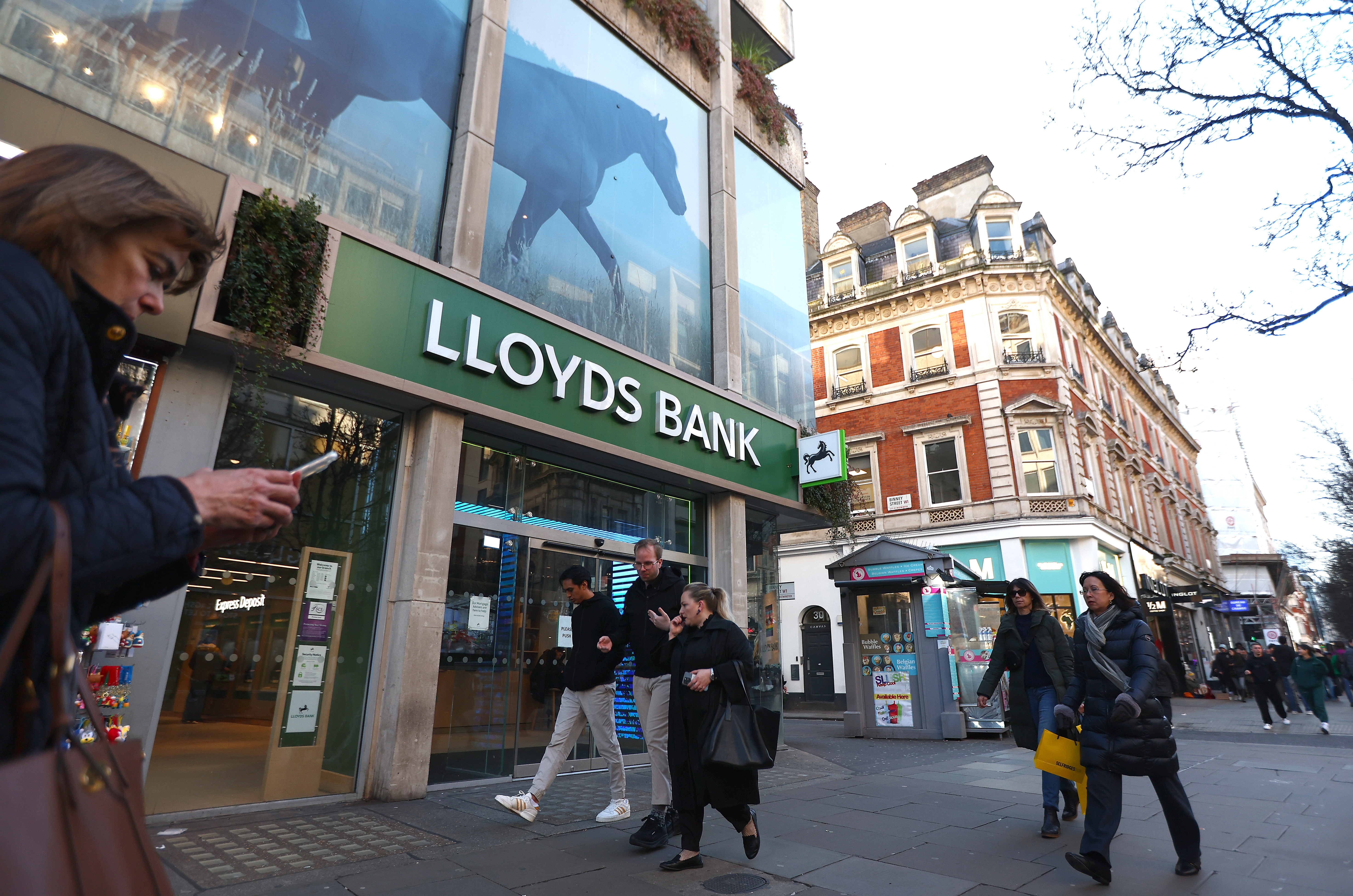 LONDON, ENGLAND - JANUARY 26: People walk past a branch of Lloyds Bank on Oxford street on January 26, 2024 in London, England. This week, Lloyds Banking Group, which also owns Bank of Scotland and Halifax, said that a branch restructuring would result in 1,600 job losses, while creating 830 roles, leading to a net reduction of 769 jobs. Many retail banks have closed branches in recent years as more customers have shifted to online banking. (Photo by Peter Nicholls/Getty Images)