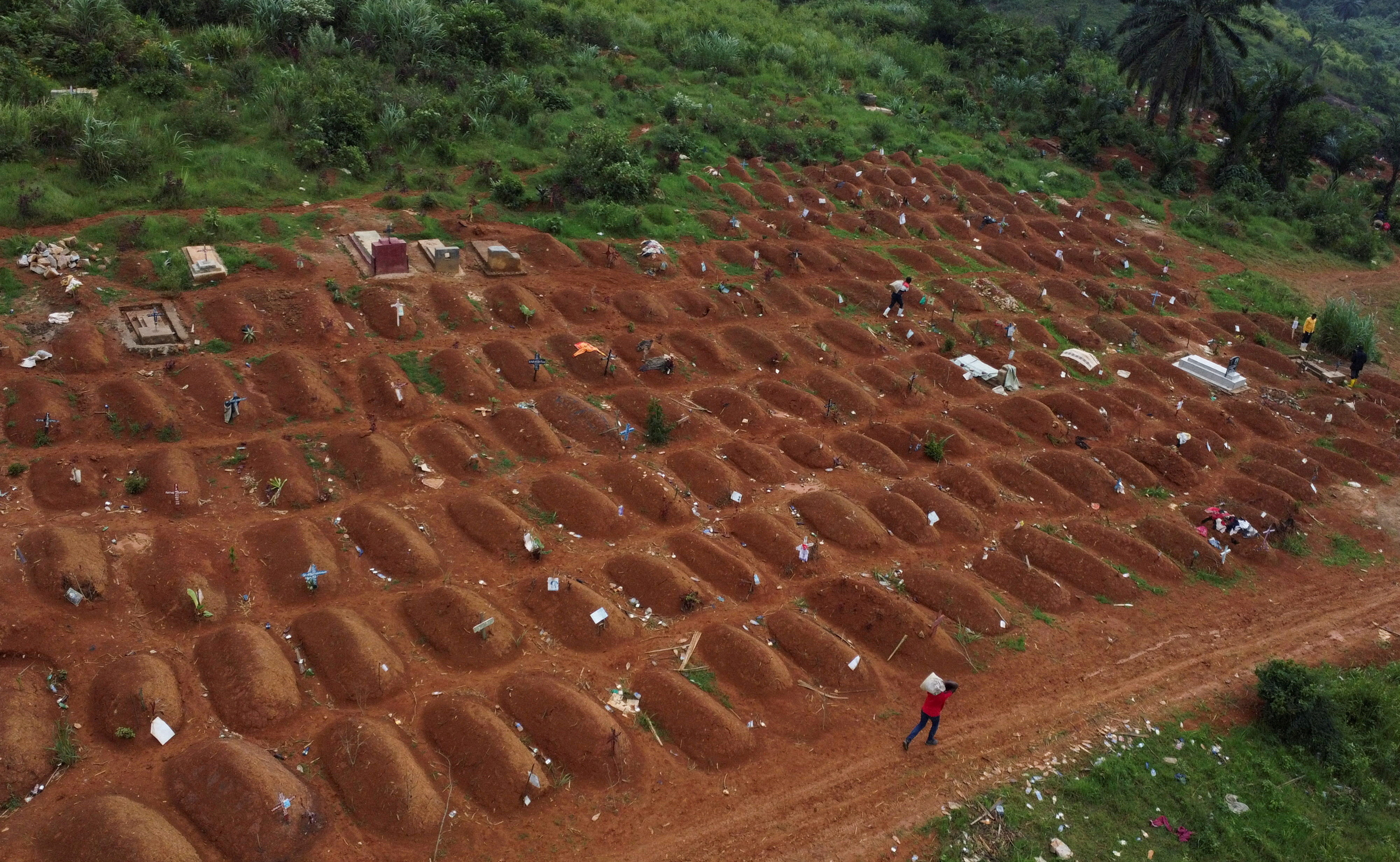 A drone view of workers at the Ceca-20 cemetery, as aid agencies intensify efforts to contain an Ebola outbreak caused by the Bundibugyo virus, in Mungwalu, Djugu Territory of Ituri province, Democratic Republic of Congo [File: Gradel Muyisa Mumbere TPX/Reuters]