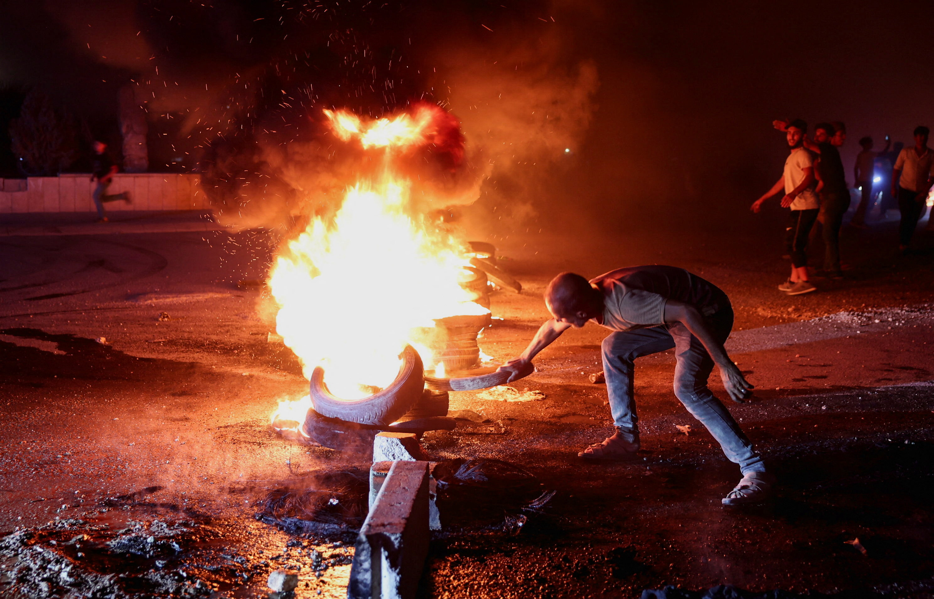 A protester in Aleppo burns tyres to protest the increase in fuel prices in Syria on the highway between Aleppo and Turkey, Syria, September 13, 2026. [Mahmoud Hassano/Reuters]
