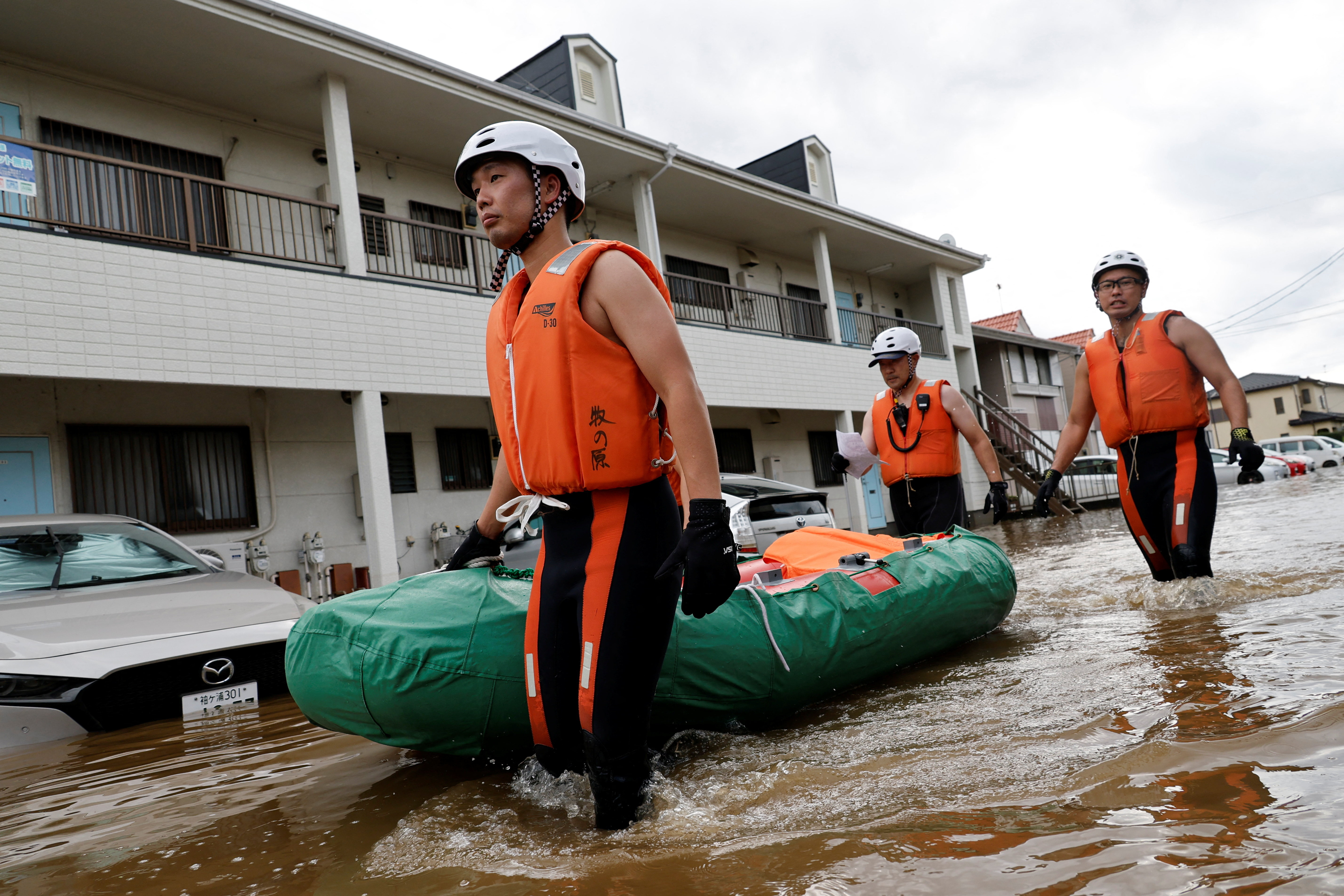 Rescue workers take an inflatable boat to rescue a stranded resident after Typhoon Dujuan brought torrential rain to Sakura, Chiba prefecture, Japan